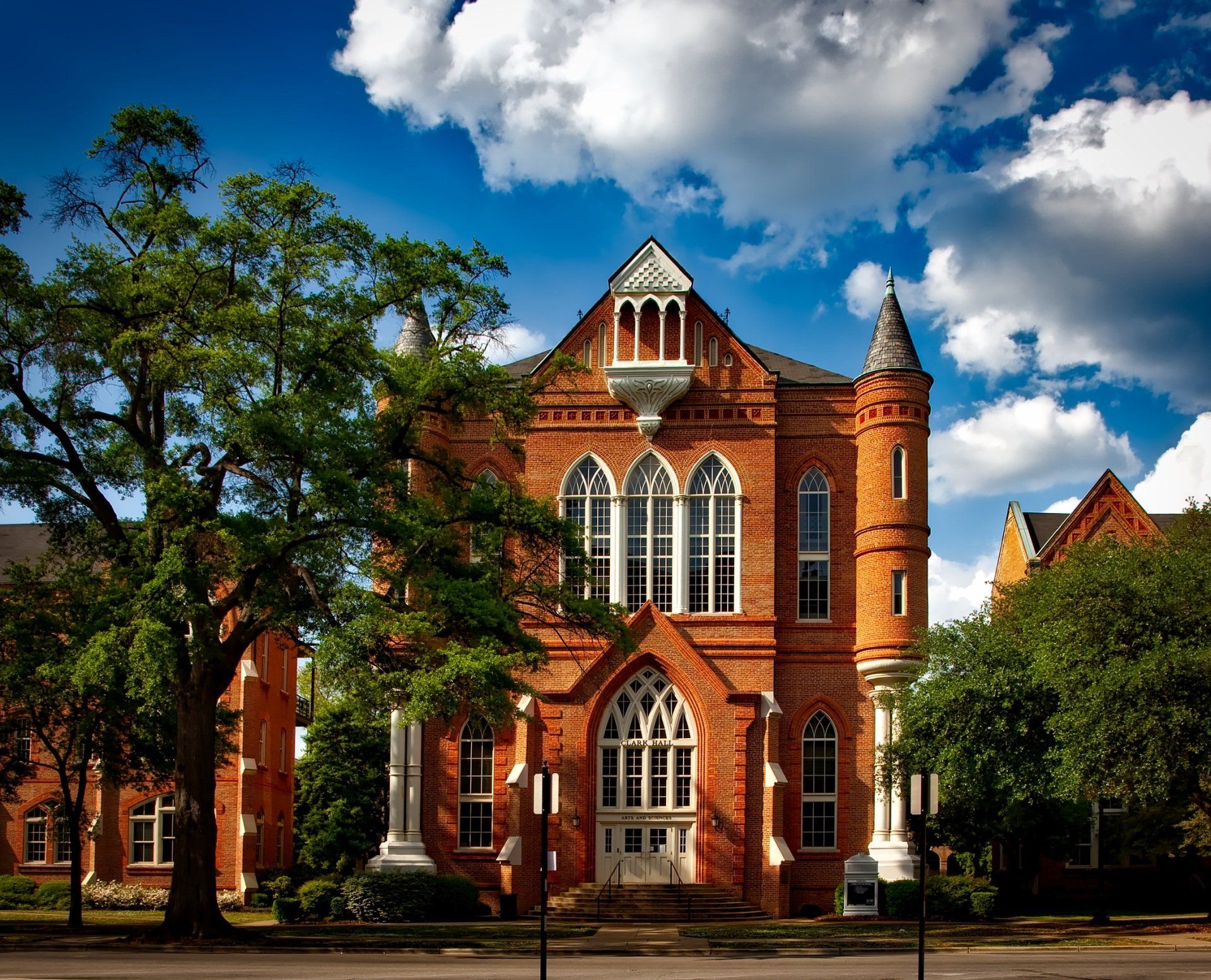 Historic red-brick university building with trees
