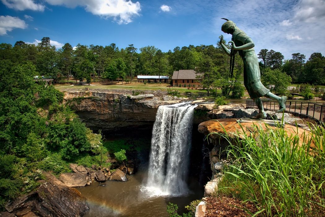 A waterfall with a statue in front of it