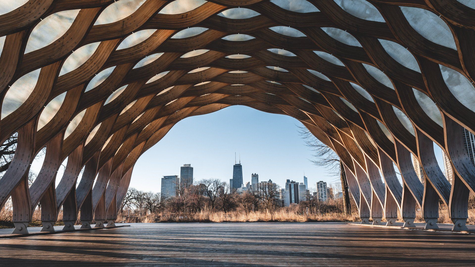 Wooden archway frames a skyline view on a clear day.