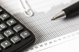 A pen is sitting next to a calculator on a graph