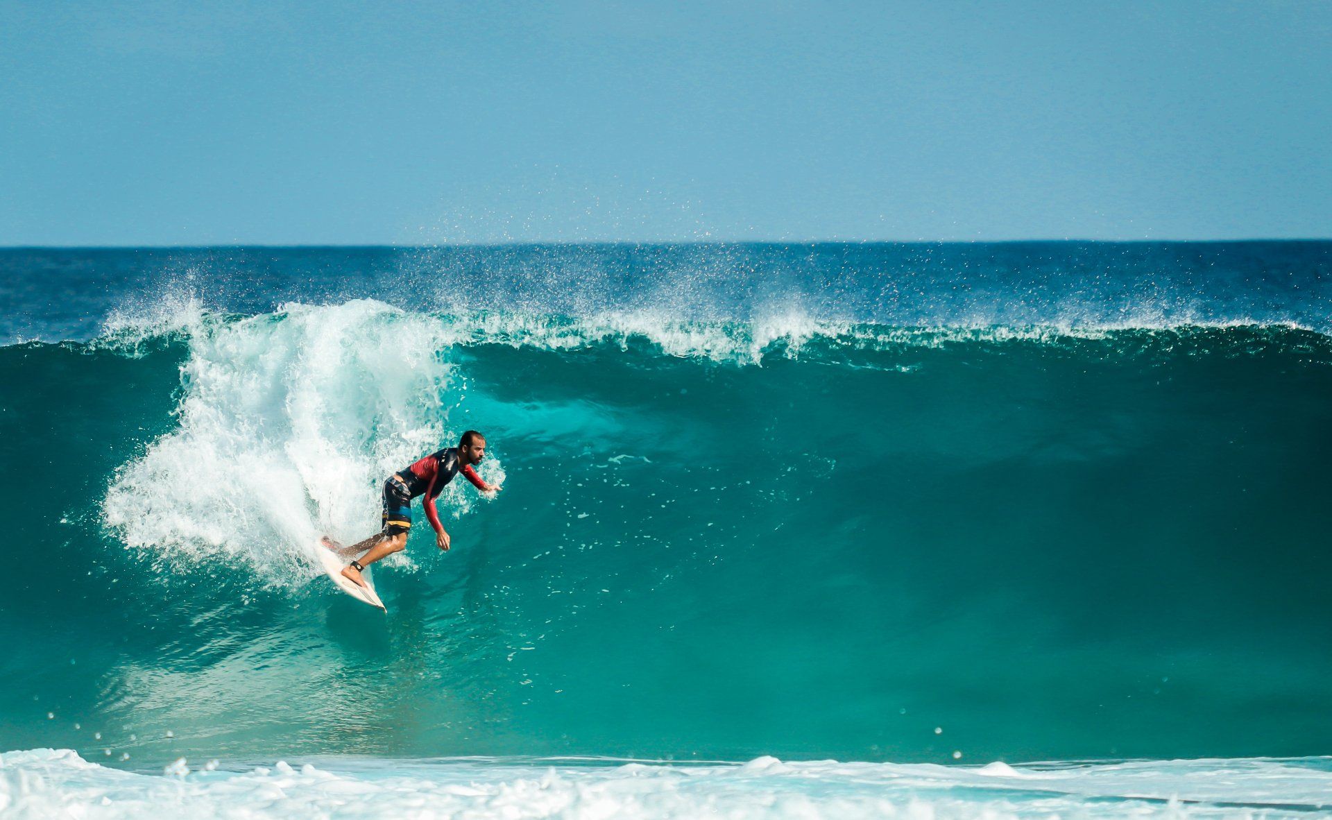 A man is riding a wave on a surfboard in the ocean.