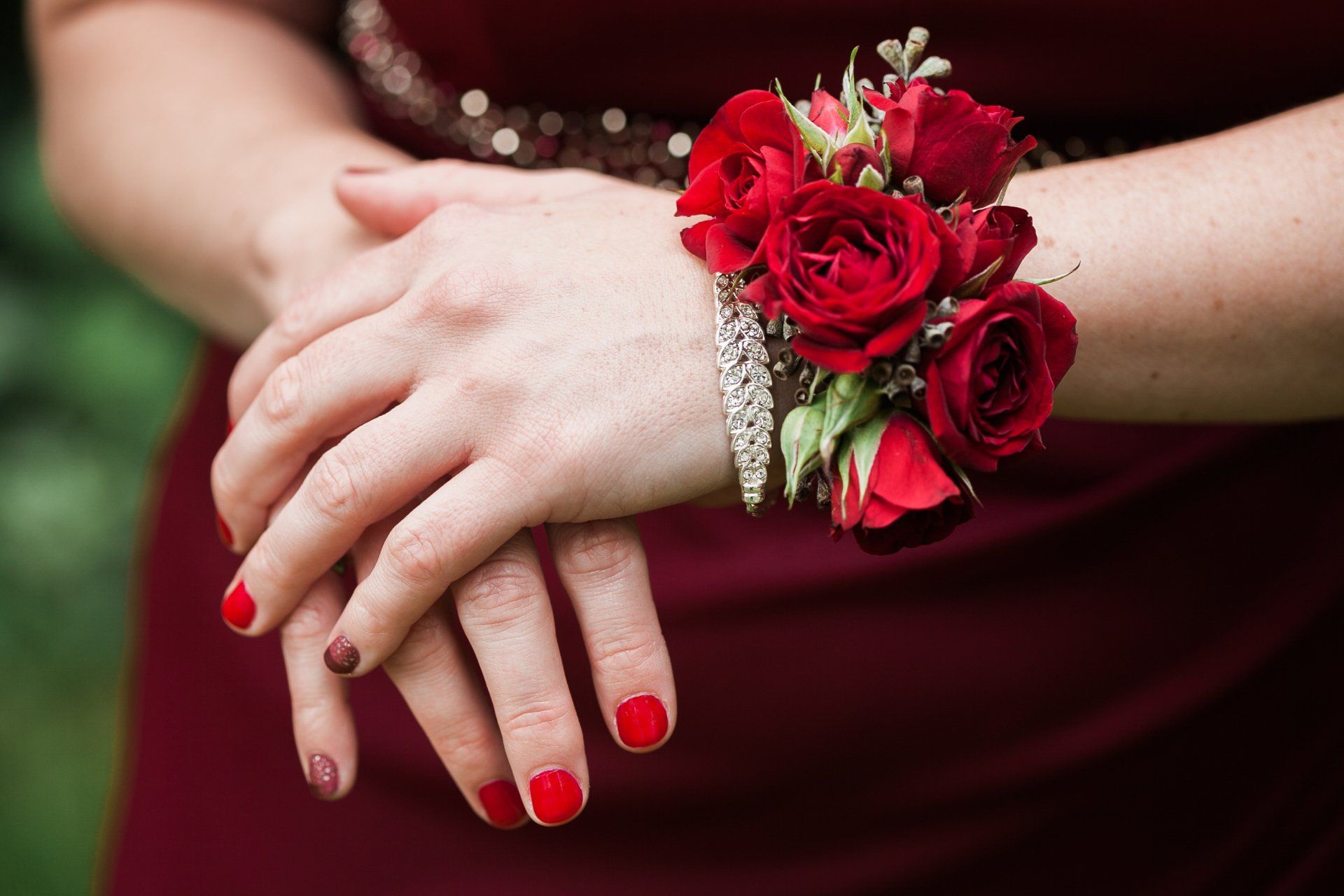 Een vrouw die een armband met rode rozen om haar pols draagt