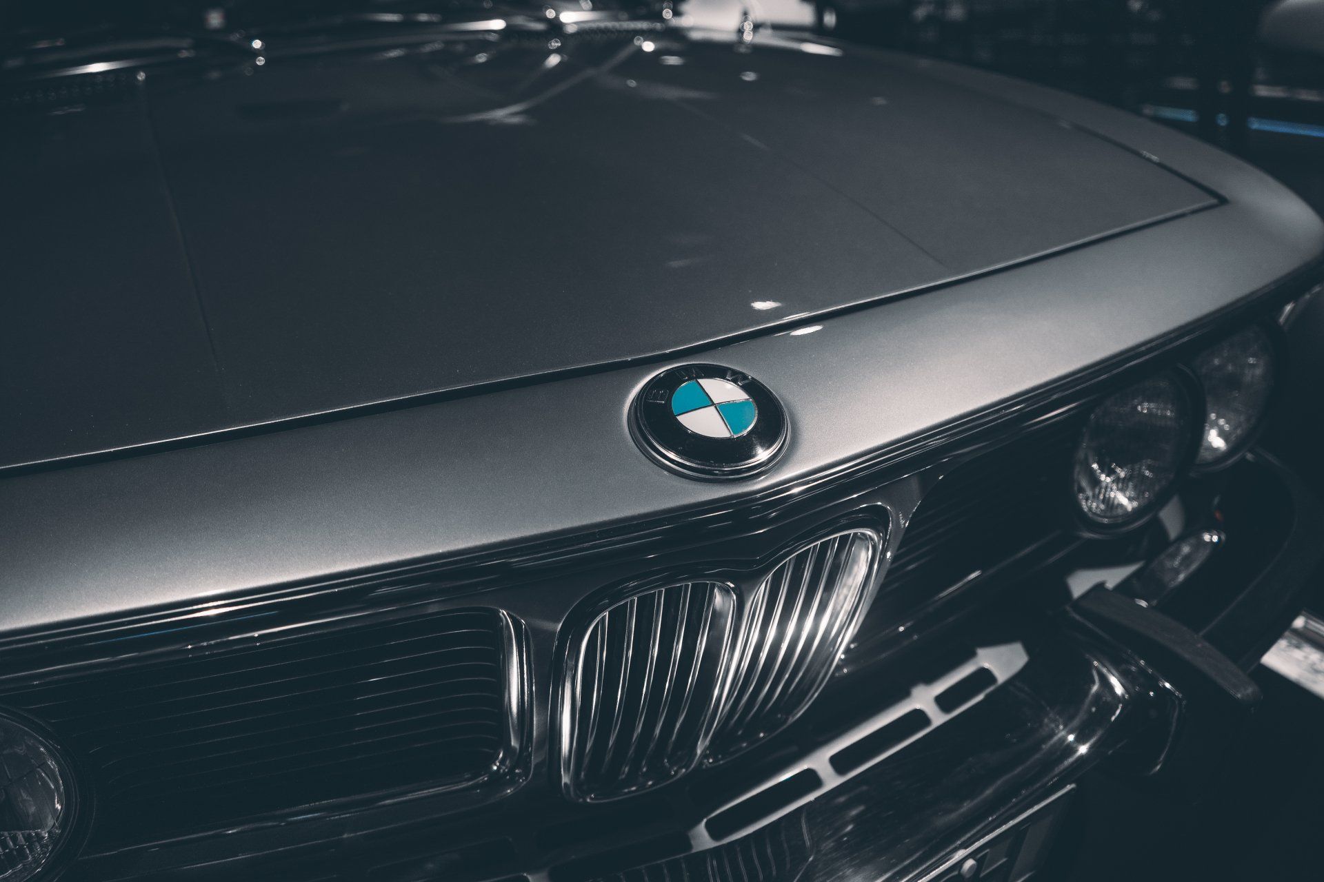 Close-up of a silver vintage BMW car's front, showcasing the logo and grill.