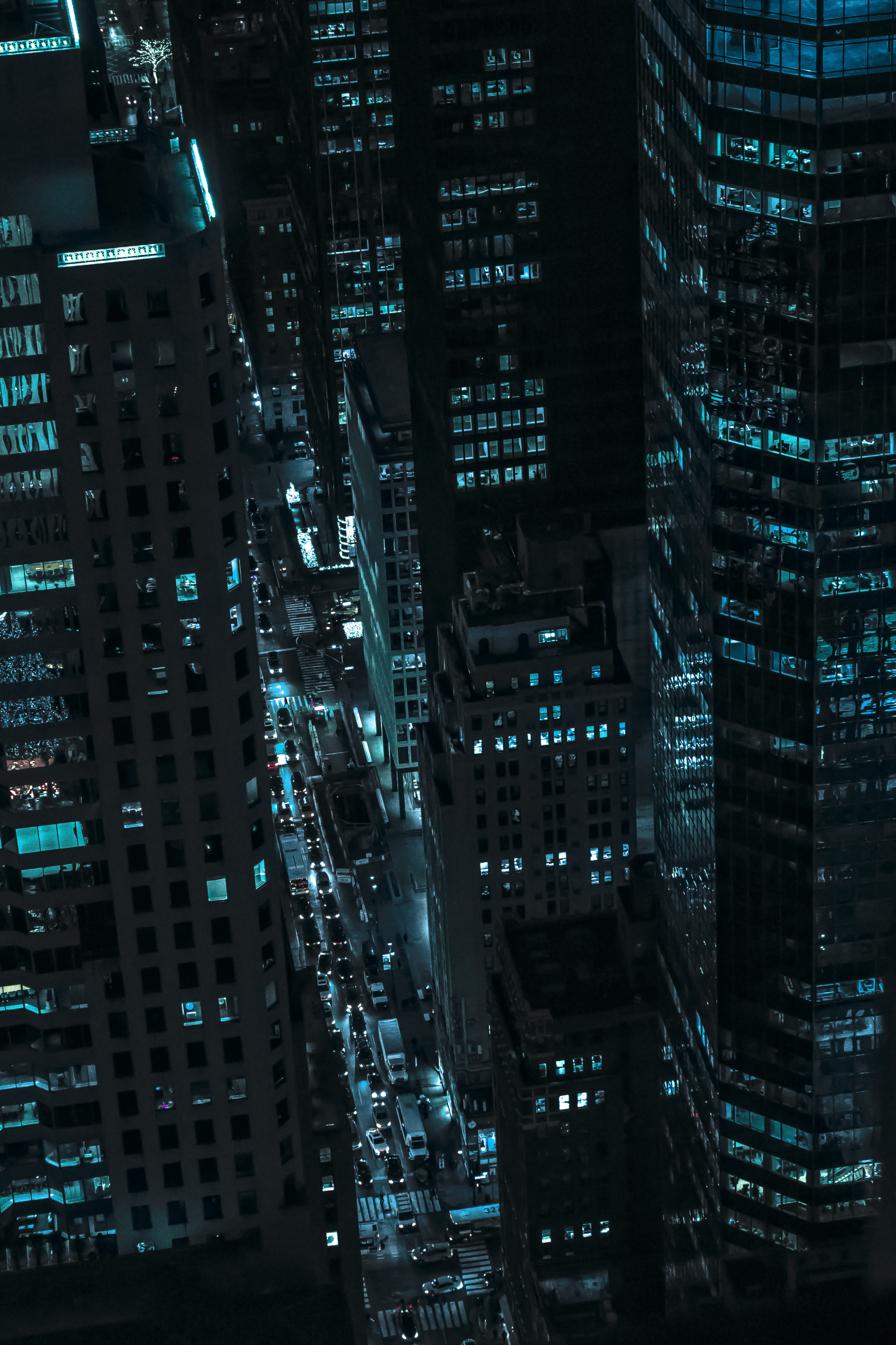 Une vue aérienne d'une ville la nuit avec beaucoup de grands immeubles.
