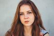 A close up of a woman with red hair looking at the camera.