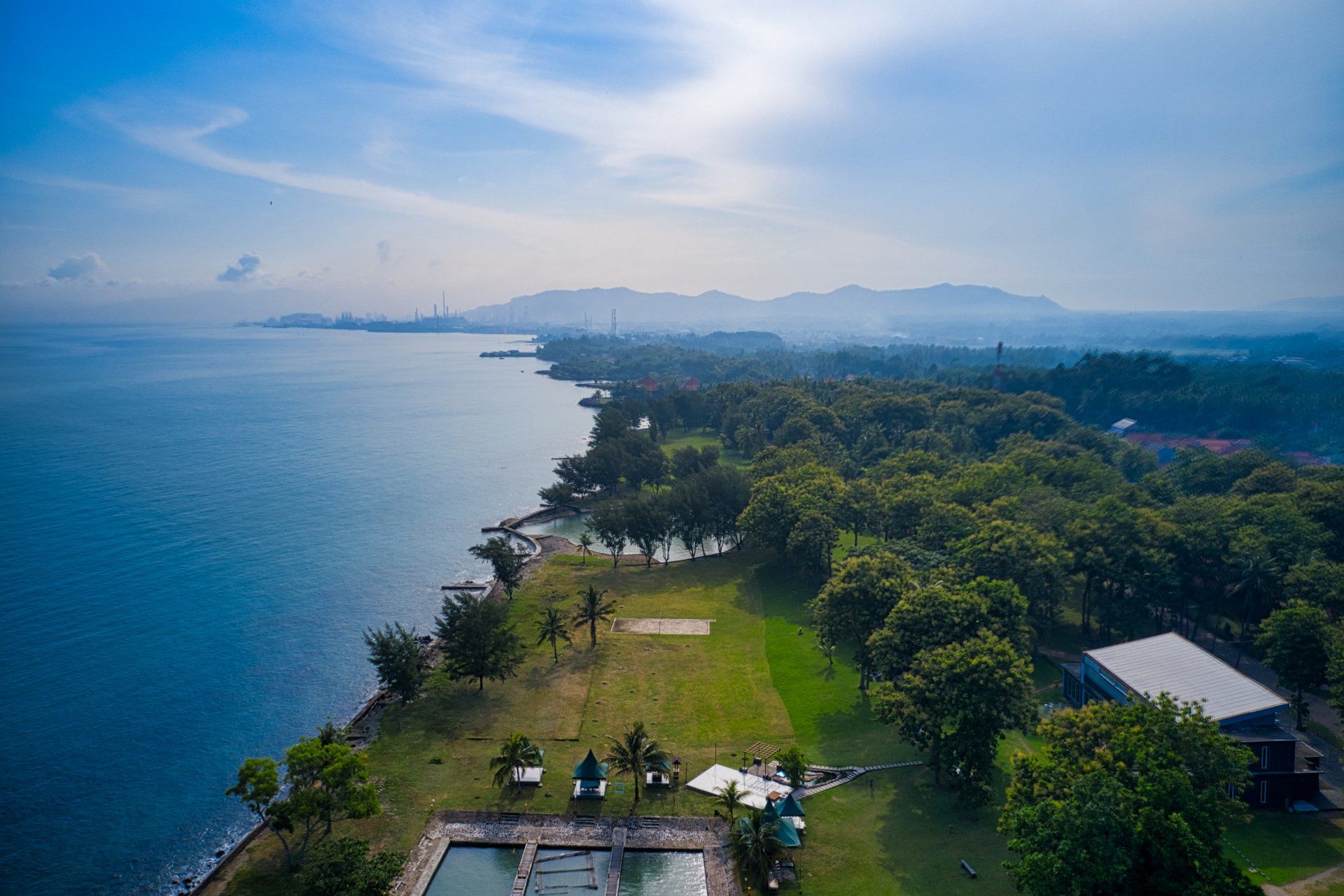 An aerial view of a lush green field next to a body of water.