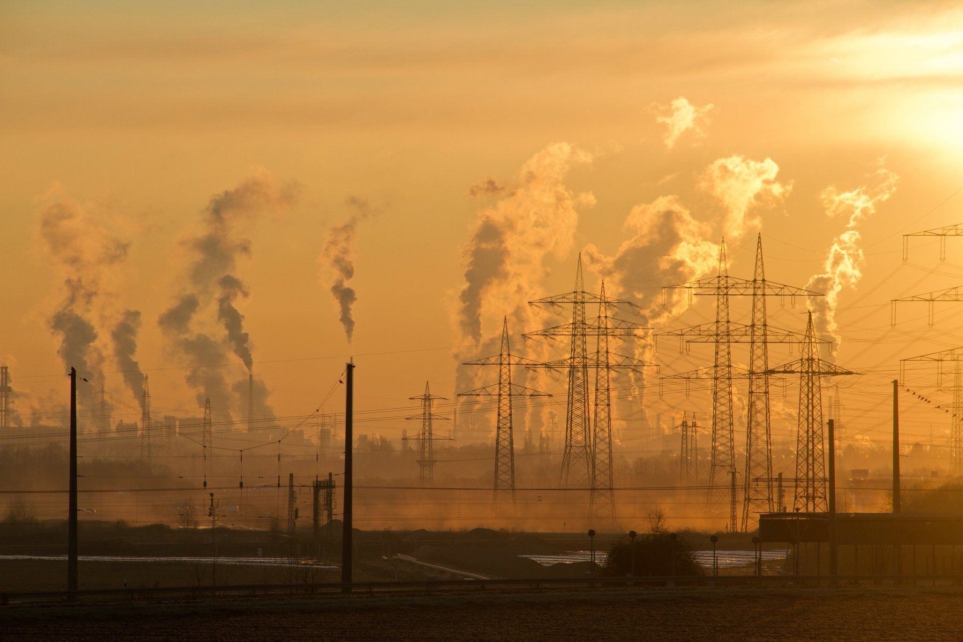 A city with yellow skylines and smog rising up from factories providing poor air quality