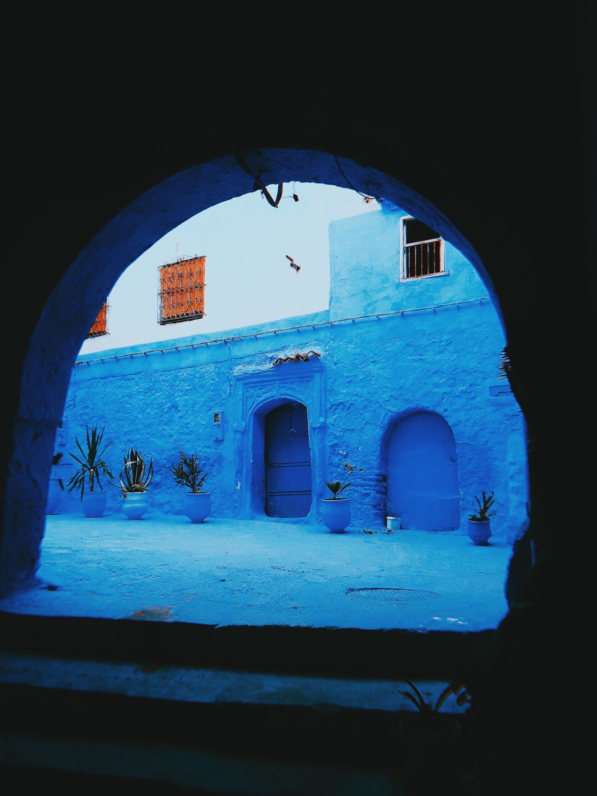 A view of a blue building through an archway
