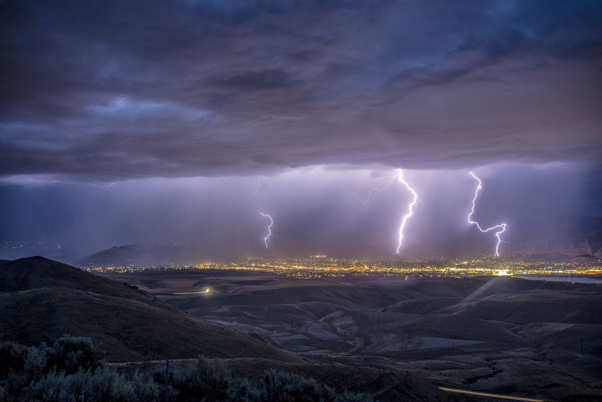 La foudre frappe le ciel au-dessus d'une ville la nuit