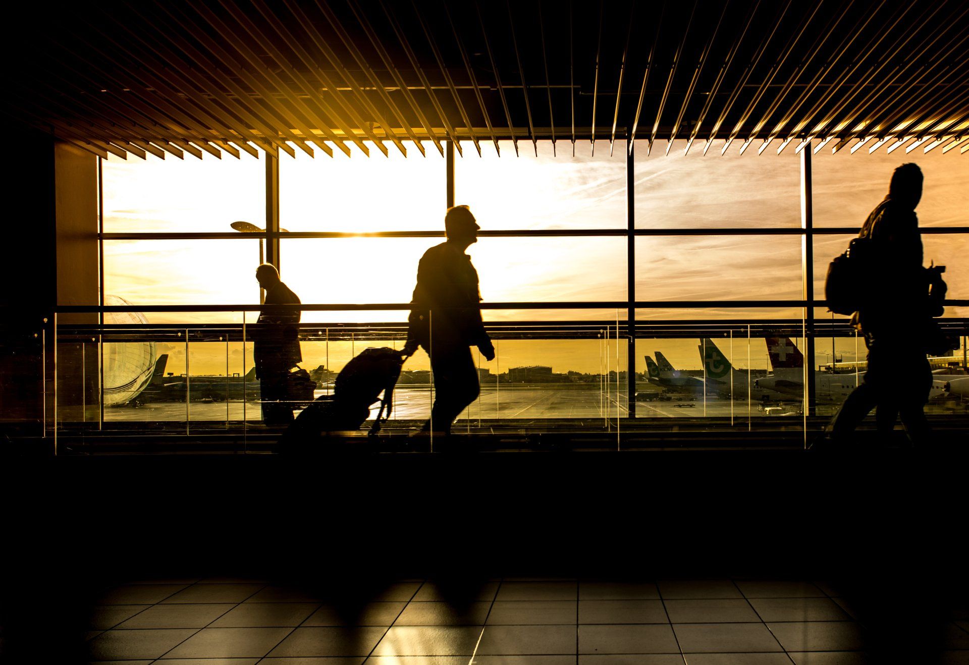 Un grupo de personas camina por un aeropuerto con su equipaje.