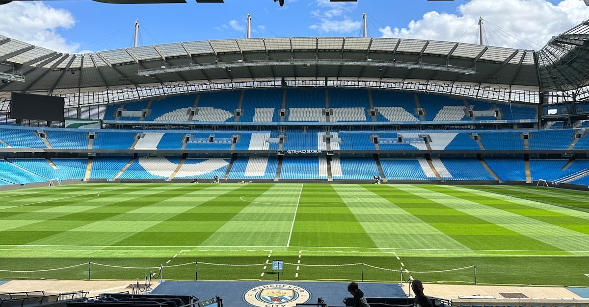 En fotballstadion med tomme seter og en grønn bane.