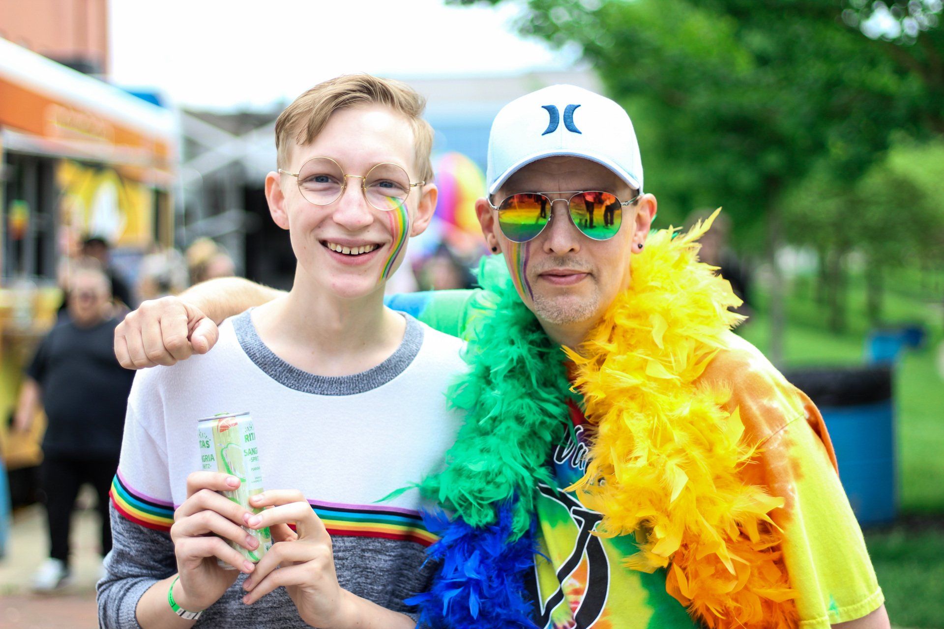 Two men are posing for a picture at a pride parade.