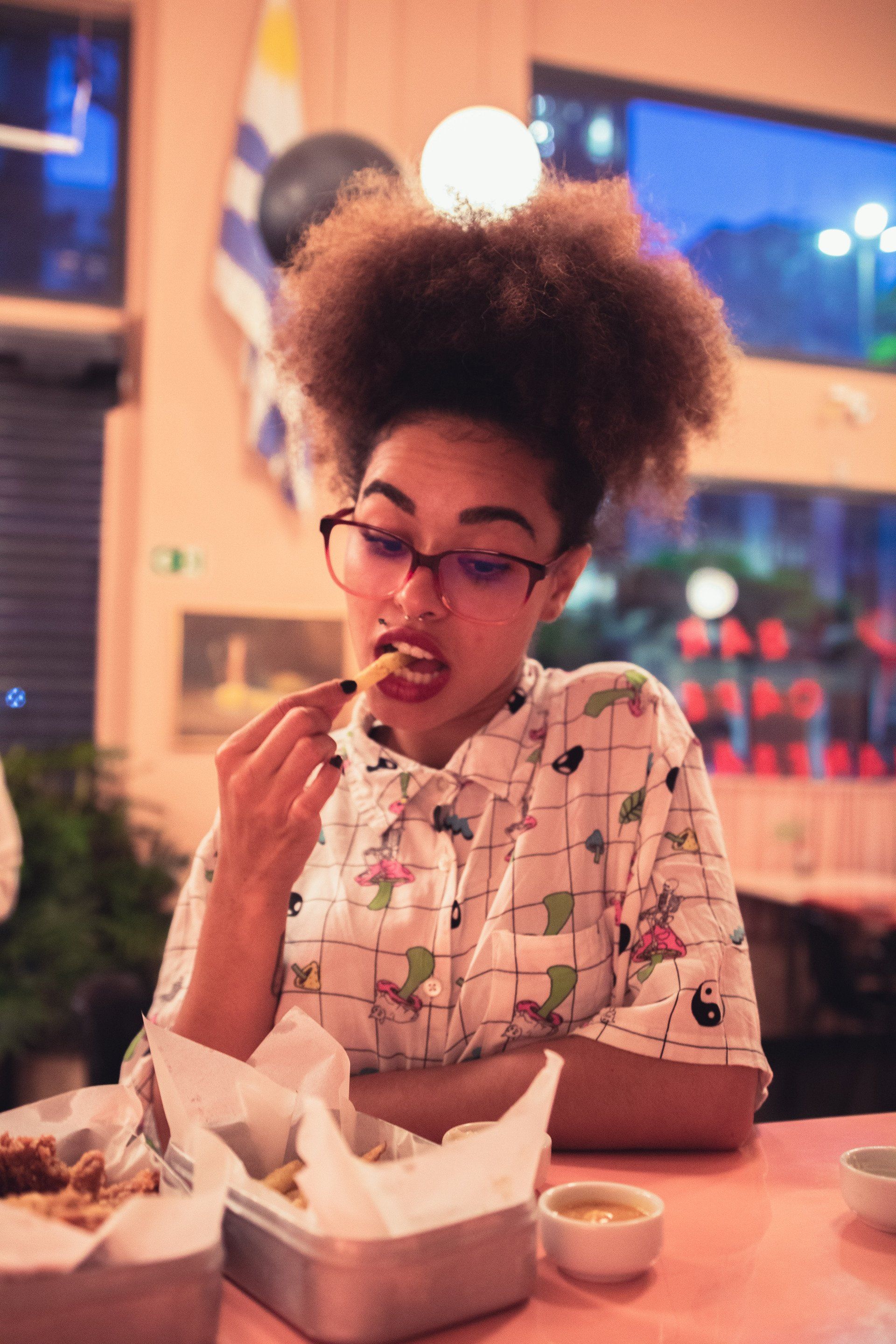 A woman is sitting at a table eating food in a restaurant.