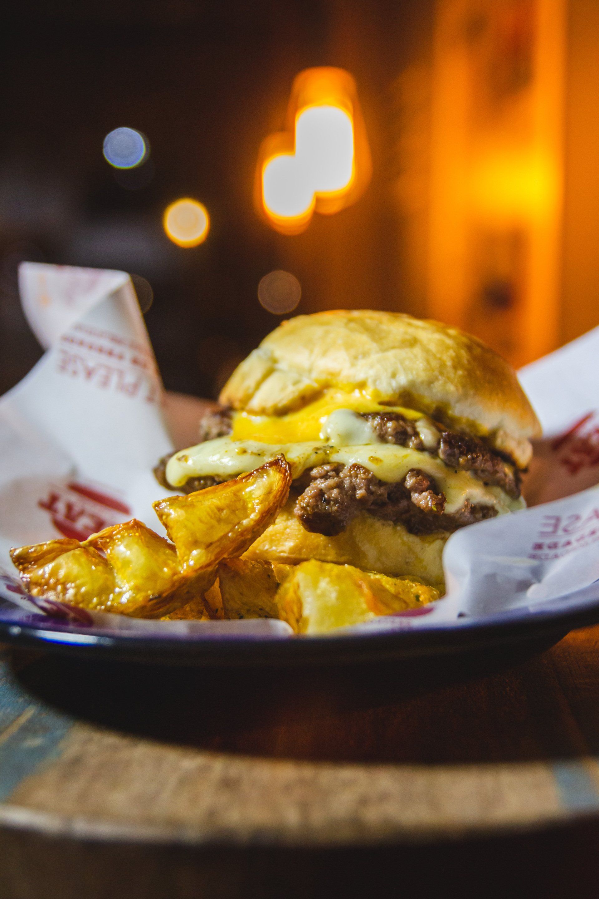 A hamburger and french fries on a plate on a table.