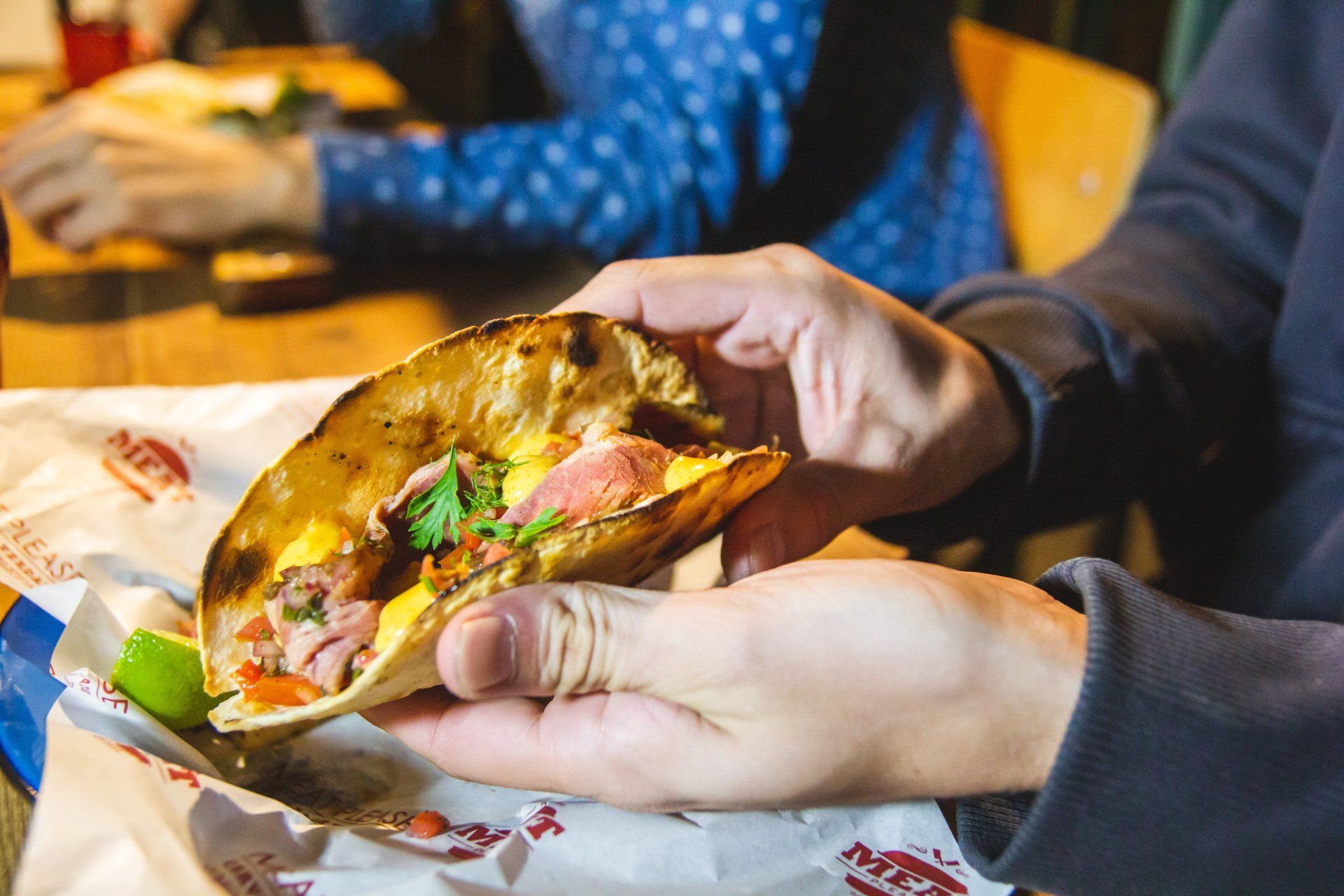 A person is holding a taco in their hands.