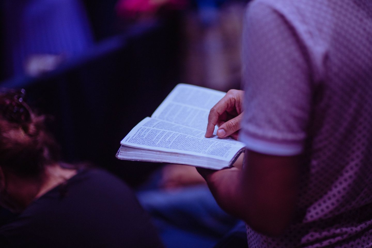 A man is reading a bible in a church.