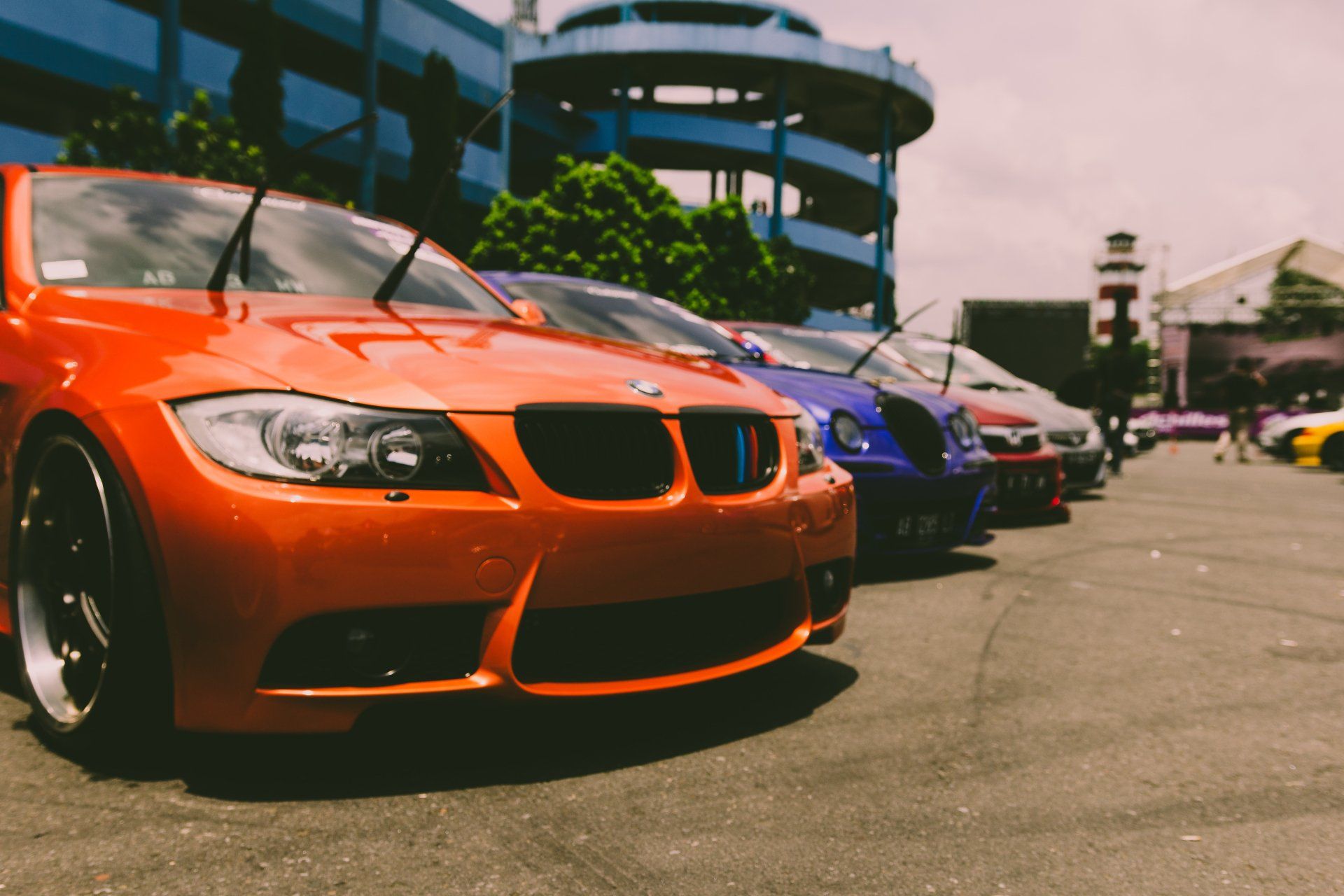 A row of cars are parked next to each other in a parking lot.