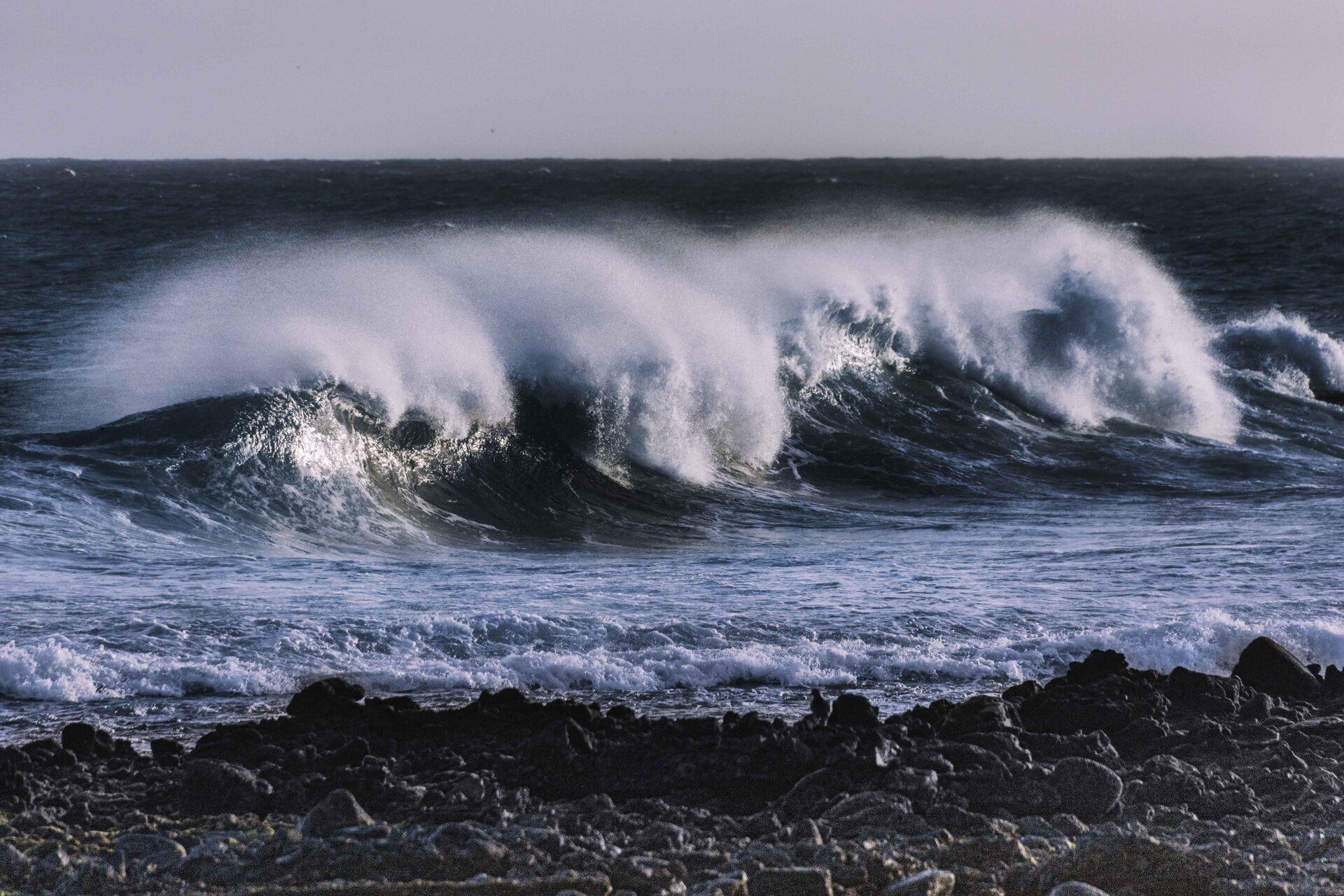 Four blue, oceanic waves -breaking on a beach