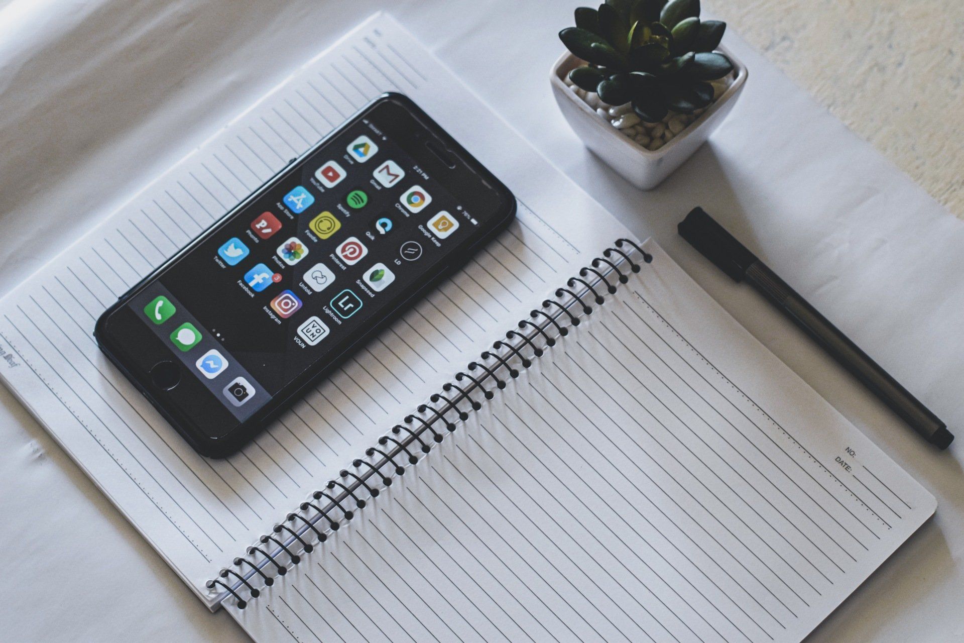 image of phone with social media icons and a notepad