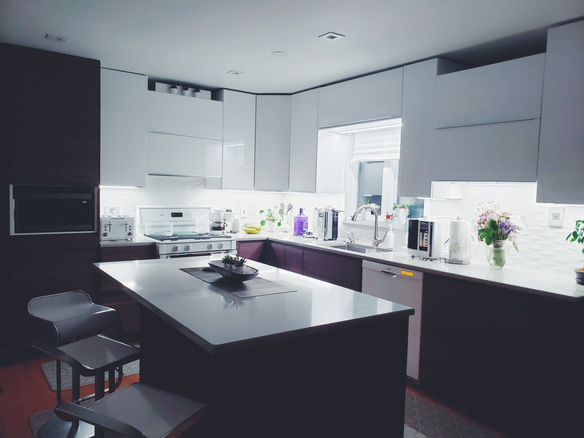 A kitchen with white cabinets and a large island in the middle