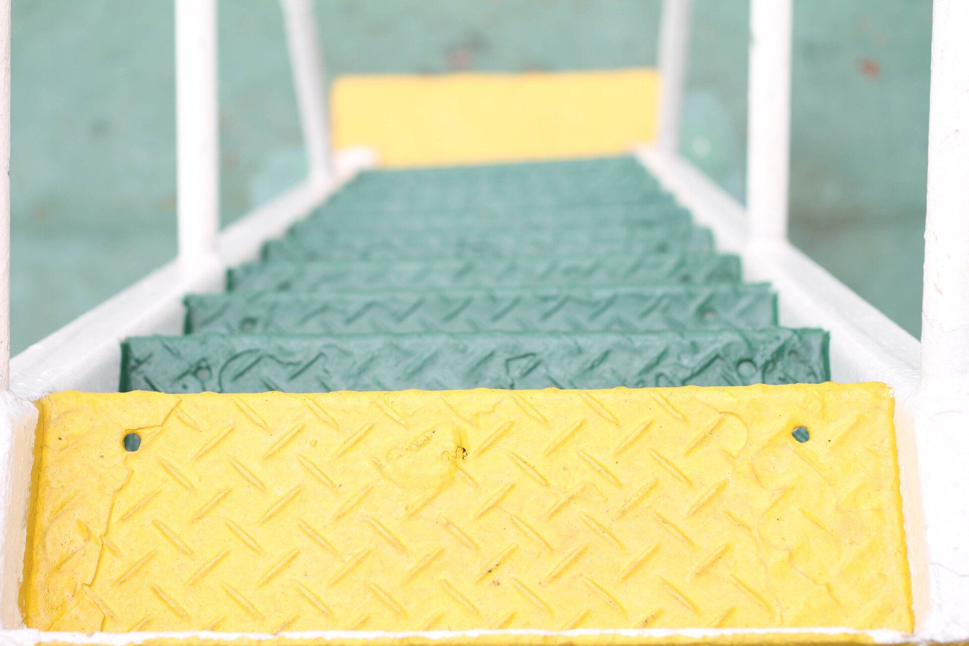 A close up of a green and yellow metal staircase.