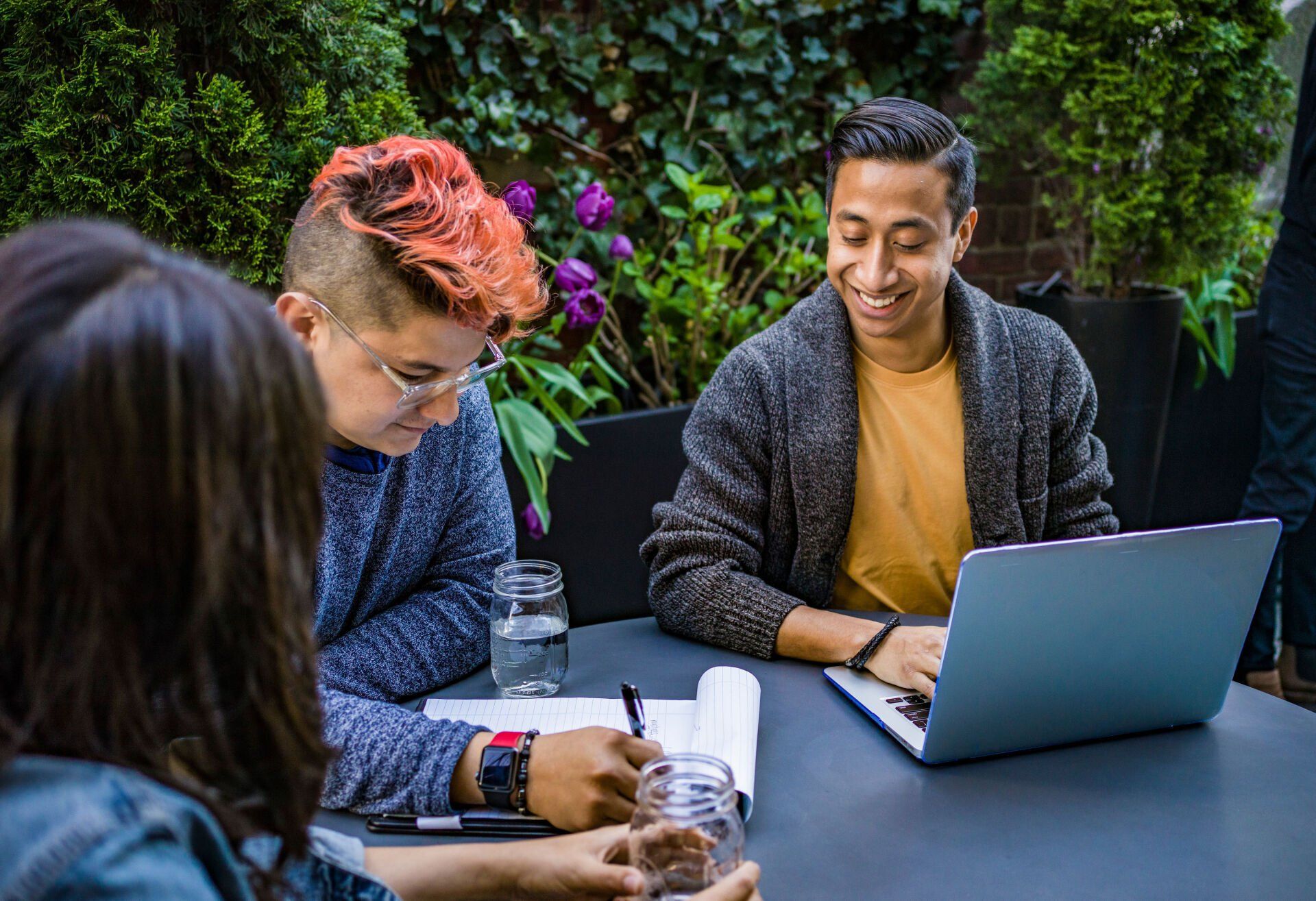 A group of people are sitting at a table with a laptop.
