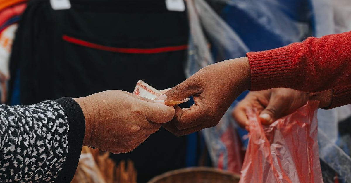 A woman is giving money to another woman at a market.