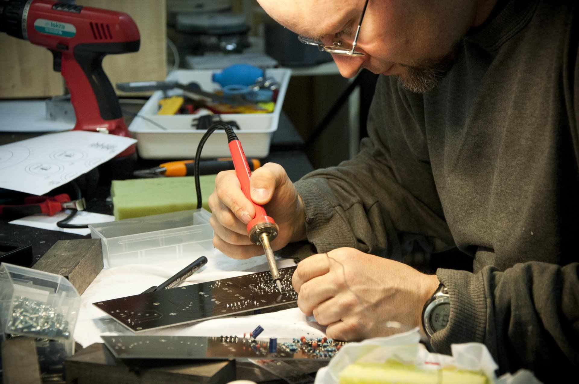 a man is working on a circuit board with a soldering iron .