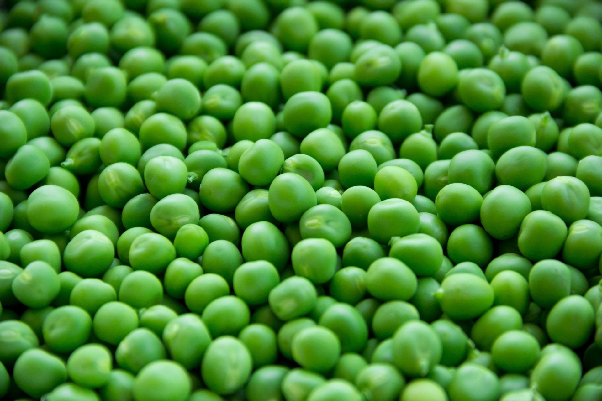 Een stapel groene erwten die op elkaar op een tafel zitten.