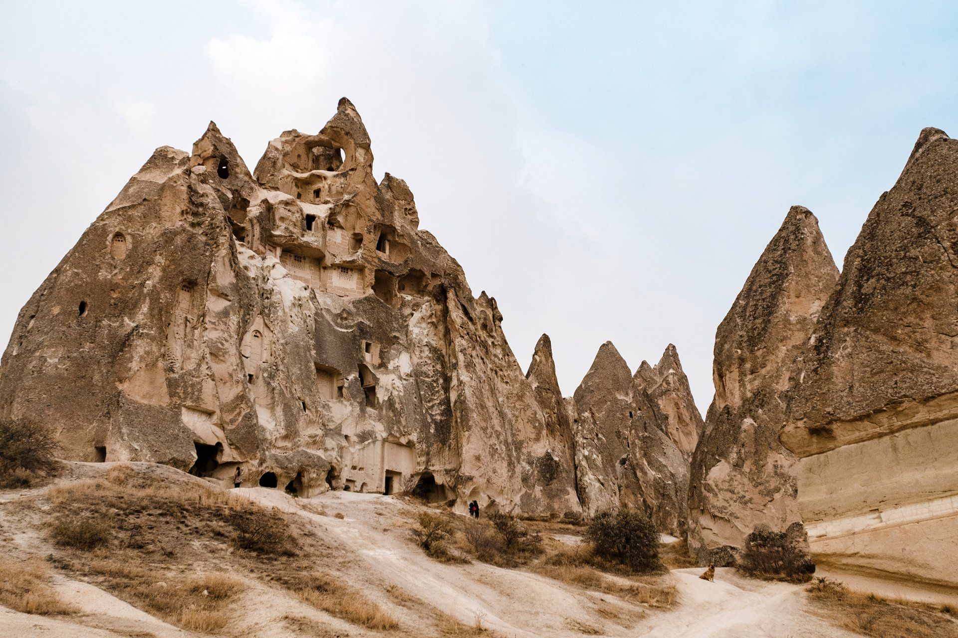 A group of rock formations in the desert with a dirt road in the foreground.