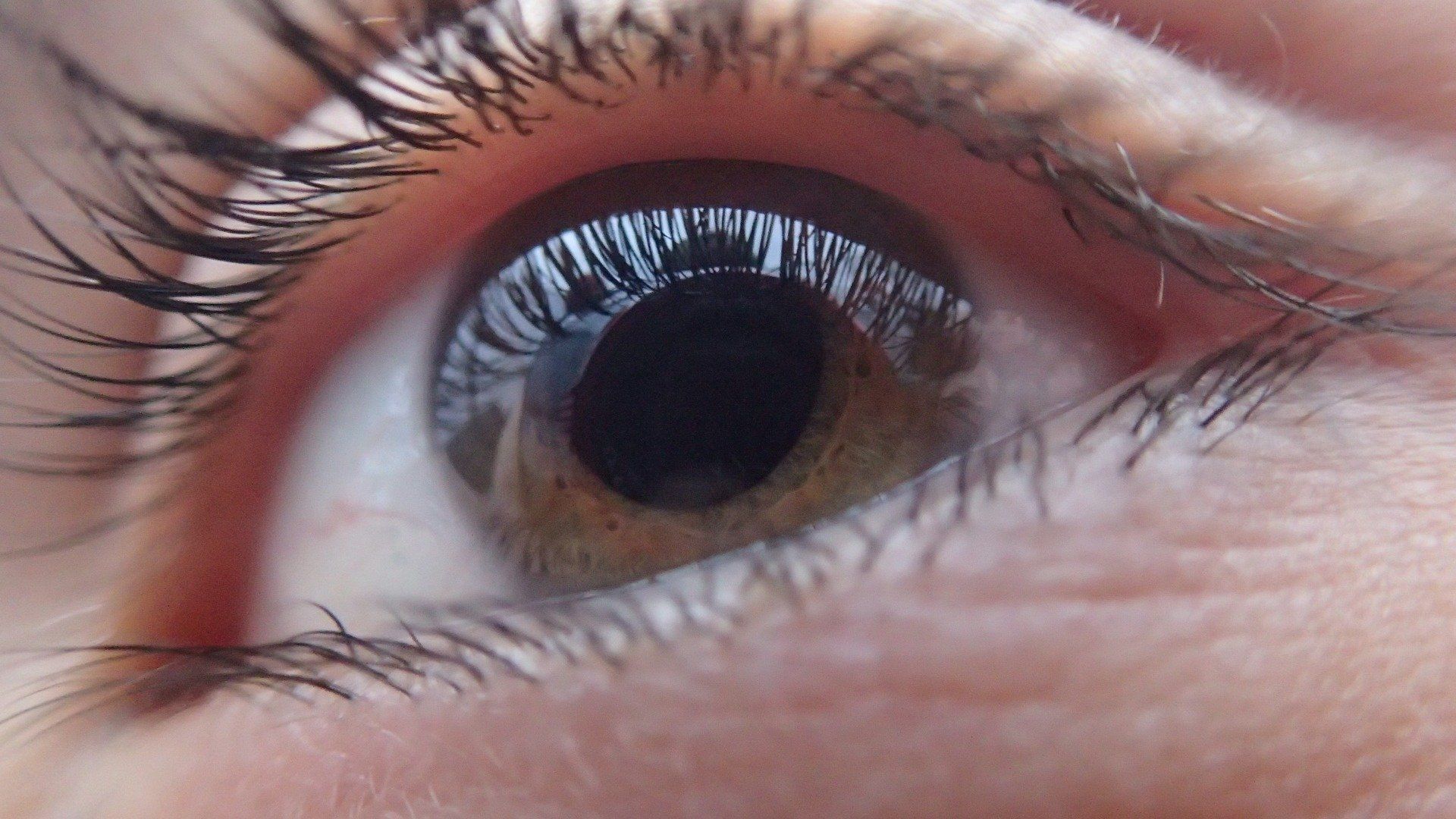 A close up of a woman 's eye with long eyelashes.
