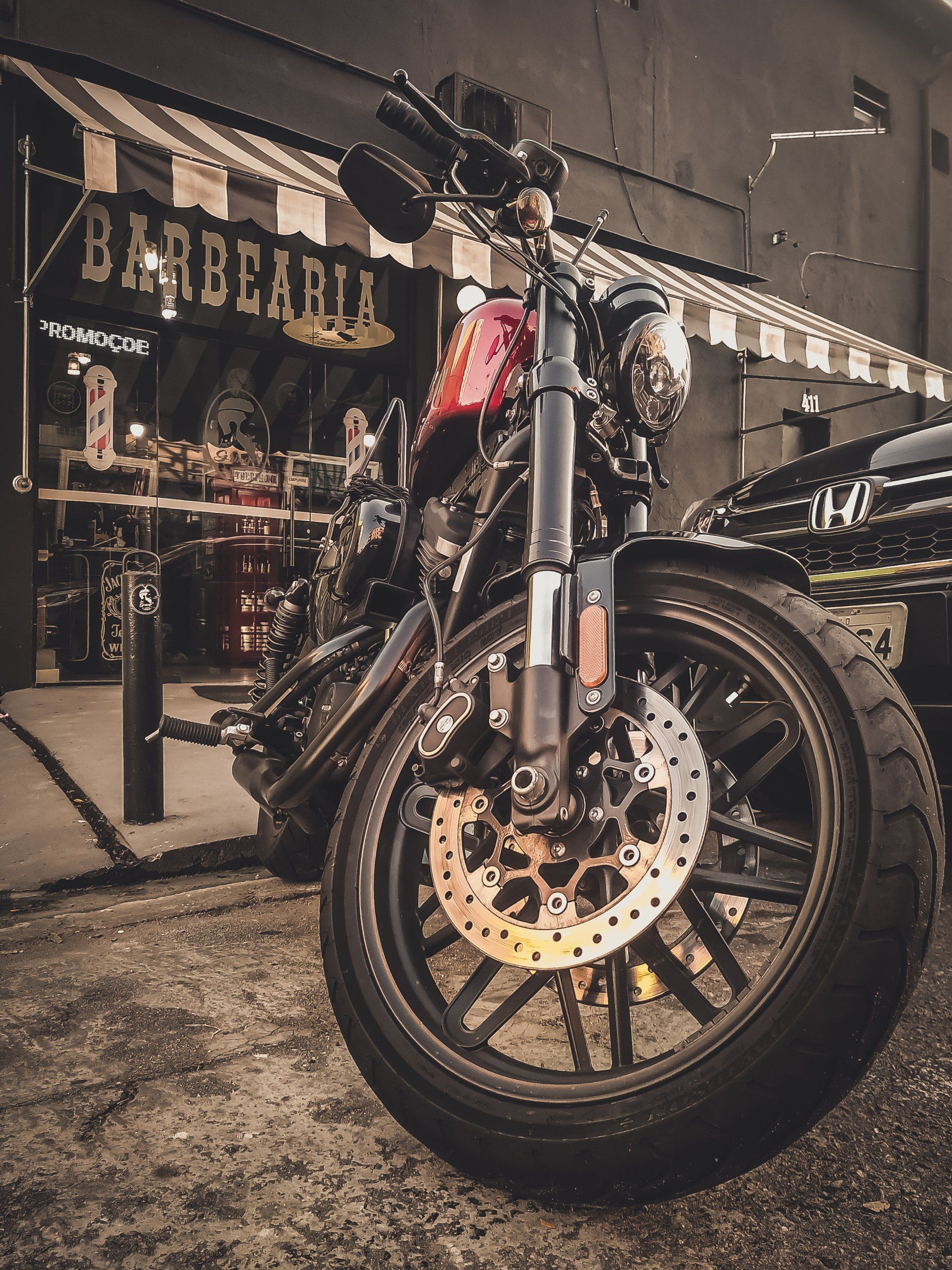 A motorcycle is parked in front of a barber shop