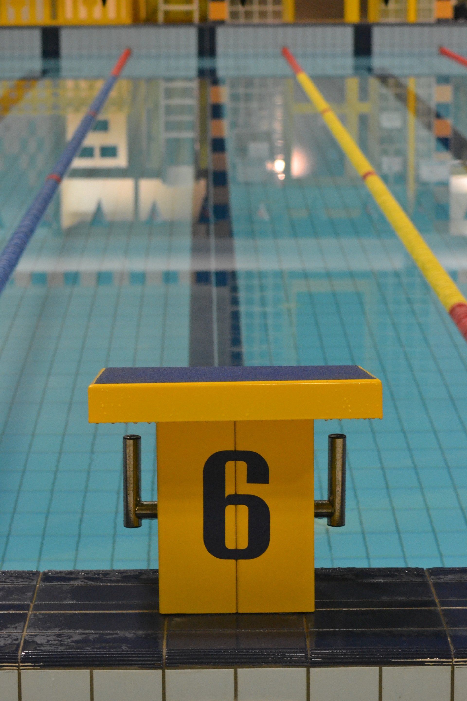 A yellow block with the number 6 on it in front of a swimming pool