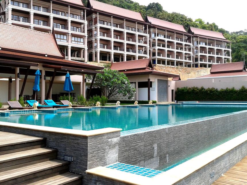 A large swimming pool in front of a hotel