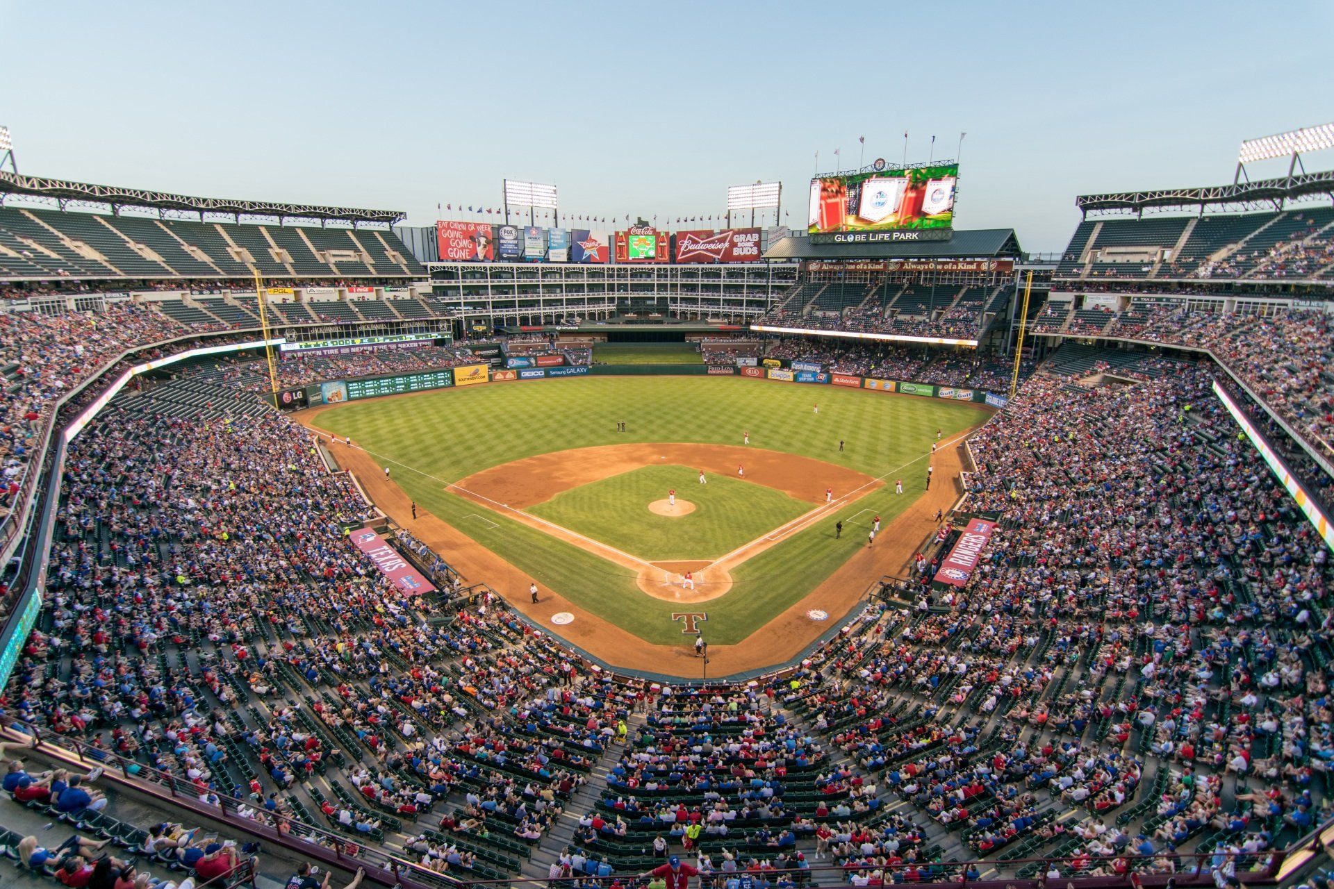 Baseball stadium filled with people watching a game.
