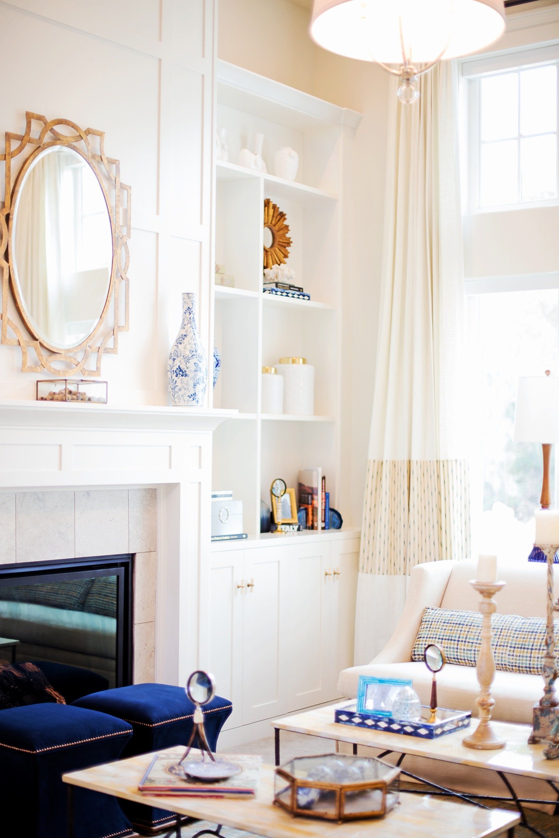 A living room with a fireplace , couch , table and mirror.
