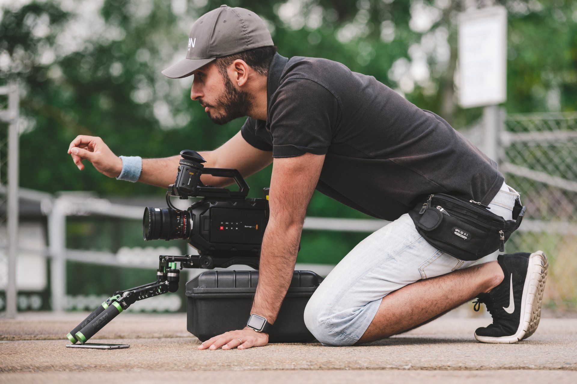 A man is kneeling down in front of a camera.