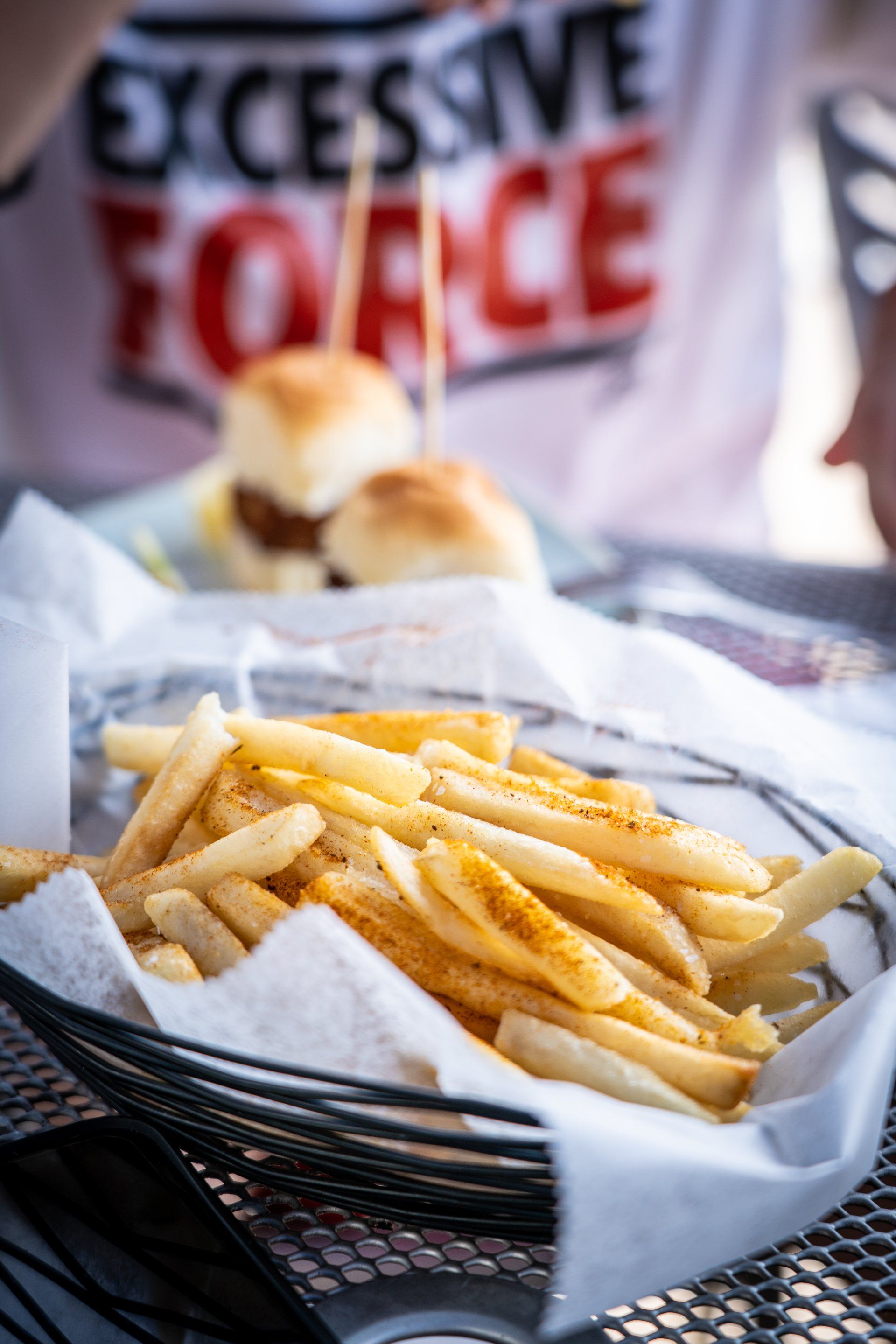 A basket of french fries is sitting on a table.