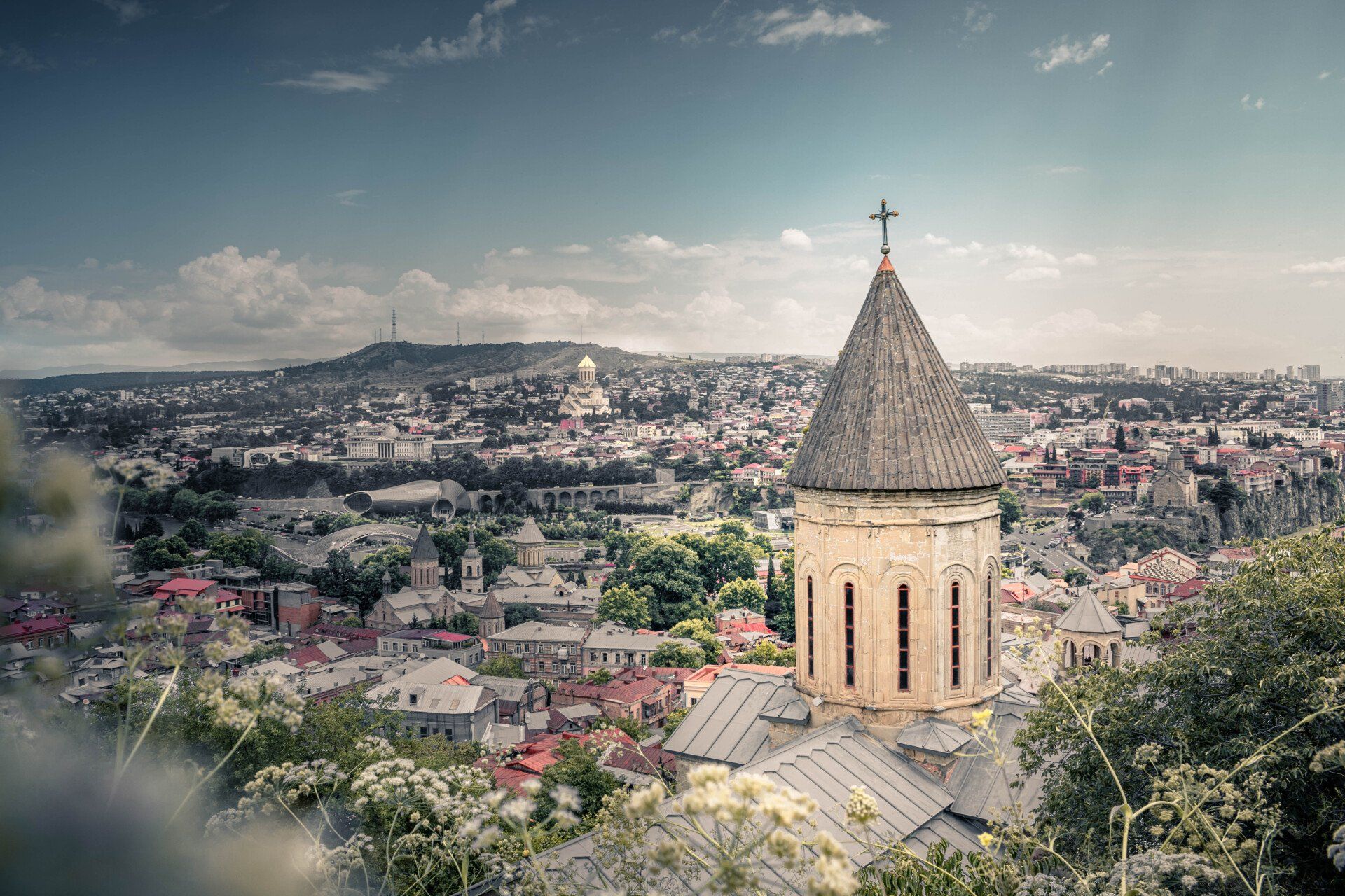 An aerial view of a church with a cross on top of it overlooking a city.