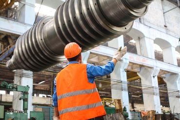Image of the back of a man in an orange hi-vis jacket and hard hat.