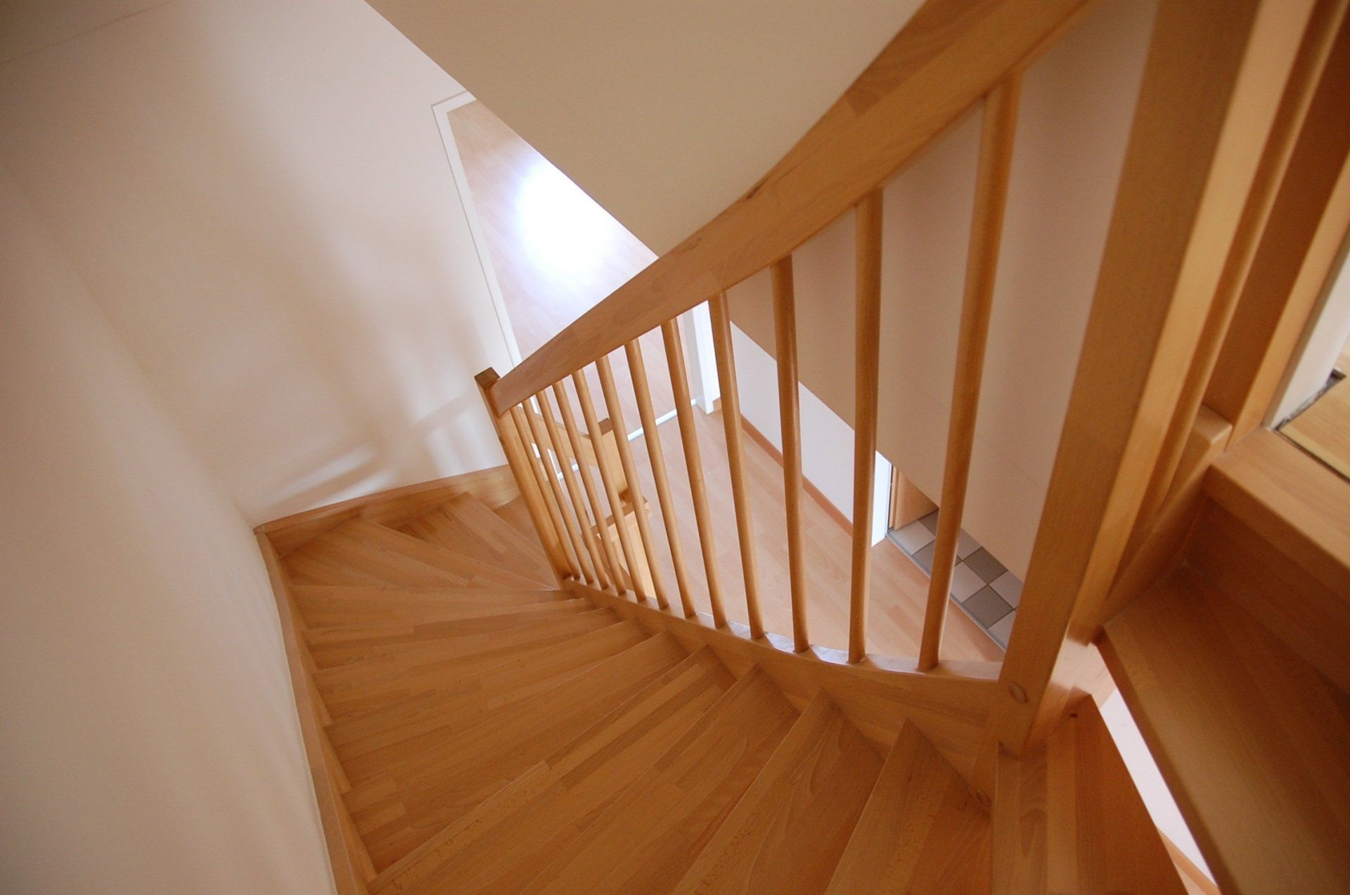 Wooden staircase with railing, leading downwards.