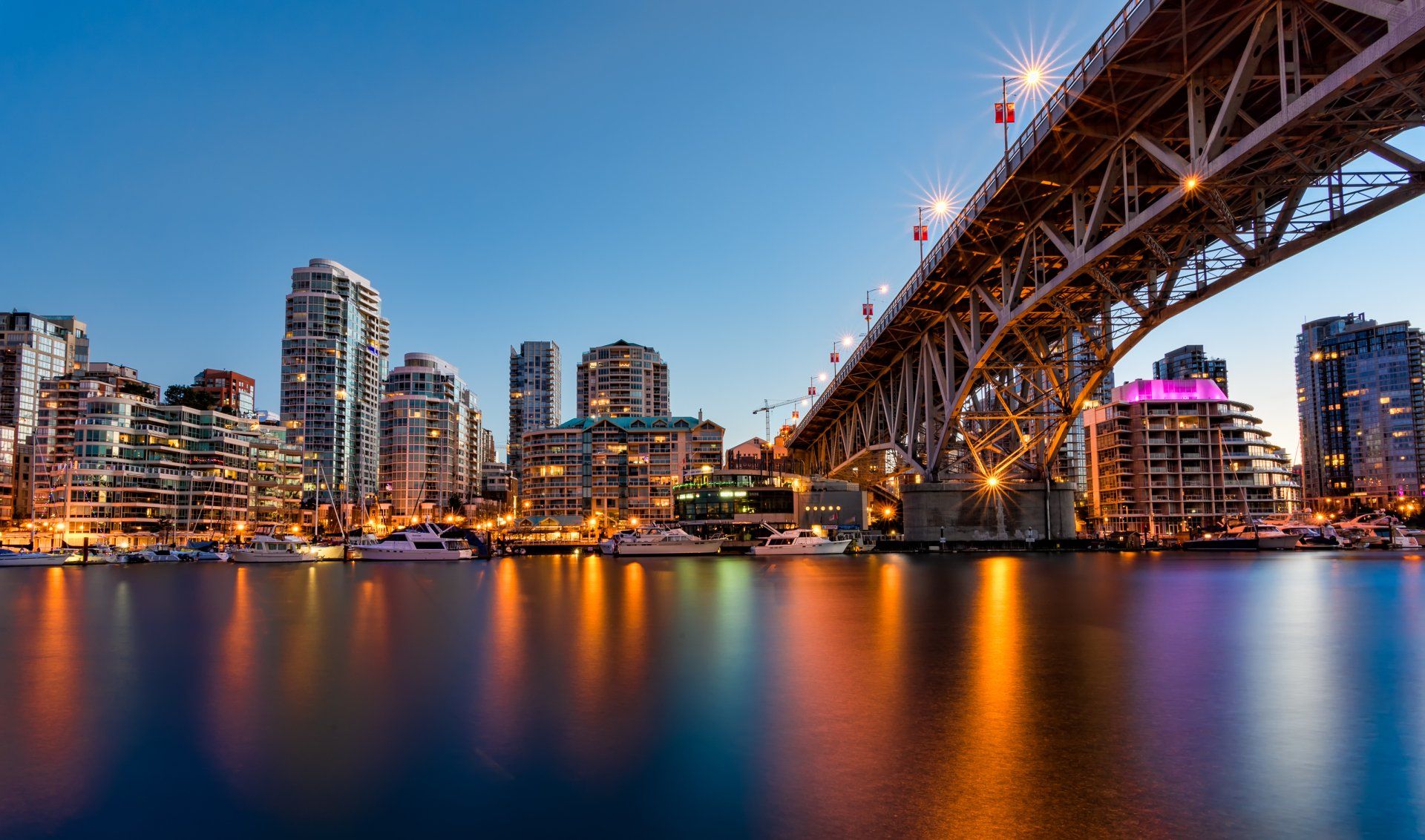 A bridge over a body of water with a city in the background.