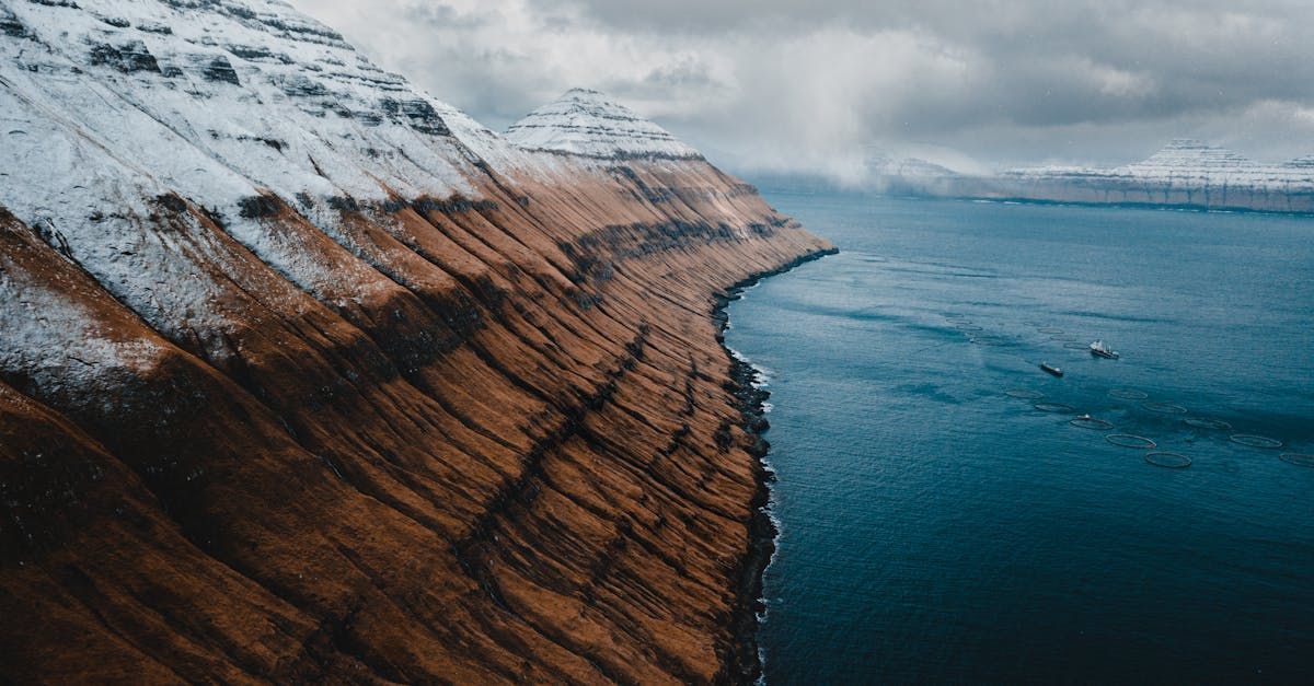 En luftfoto av en fjellklippe med utsikt over en vannmasse.