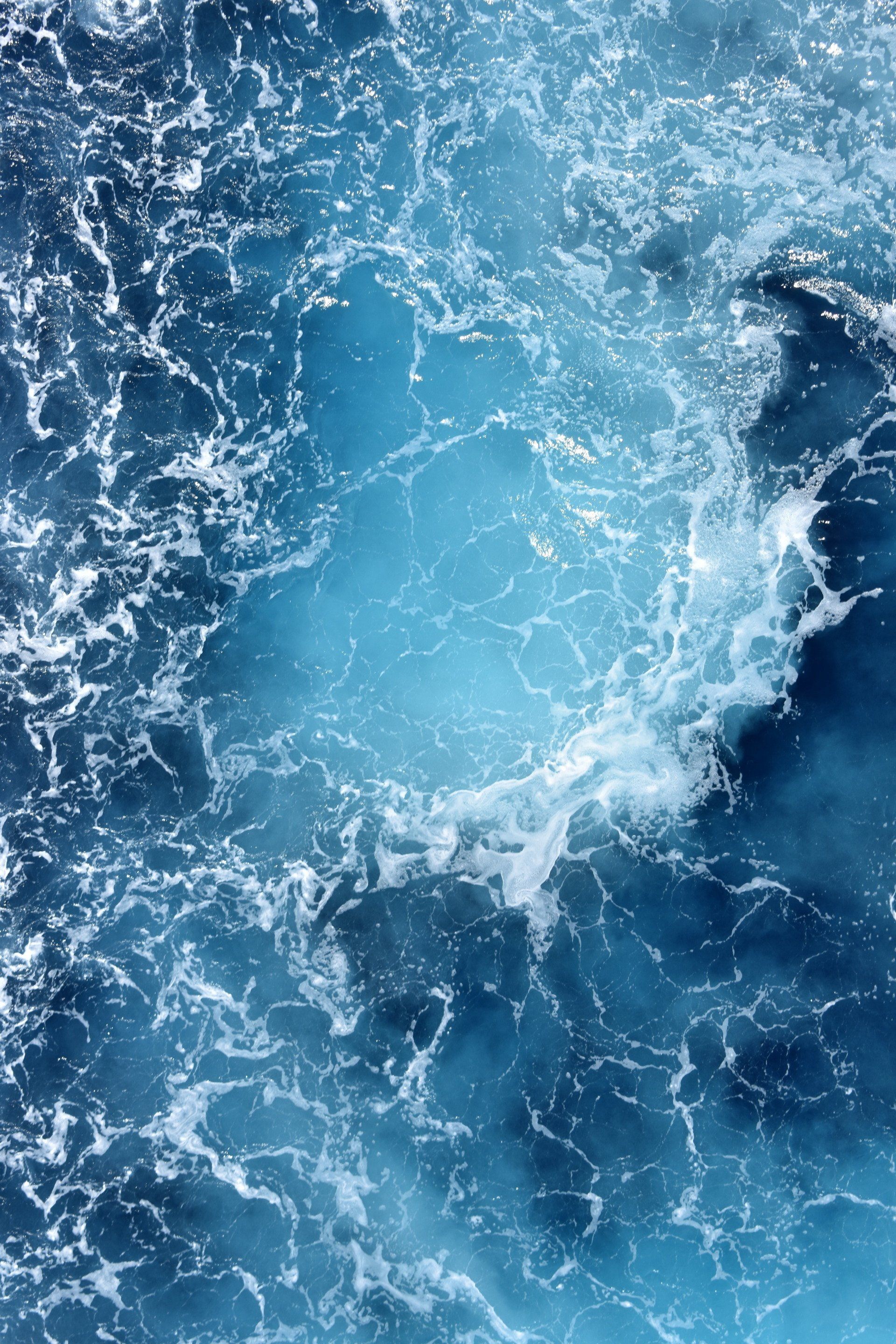 A close up of a body of water with waves and foam