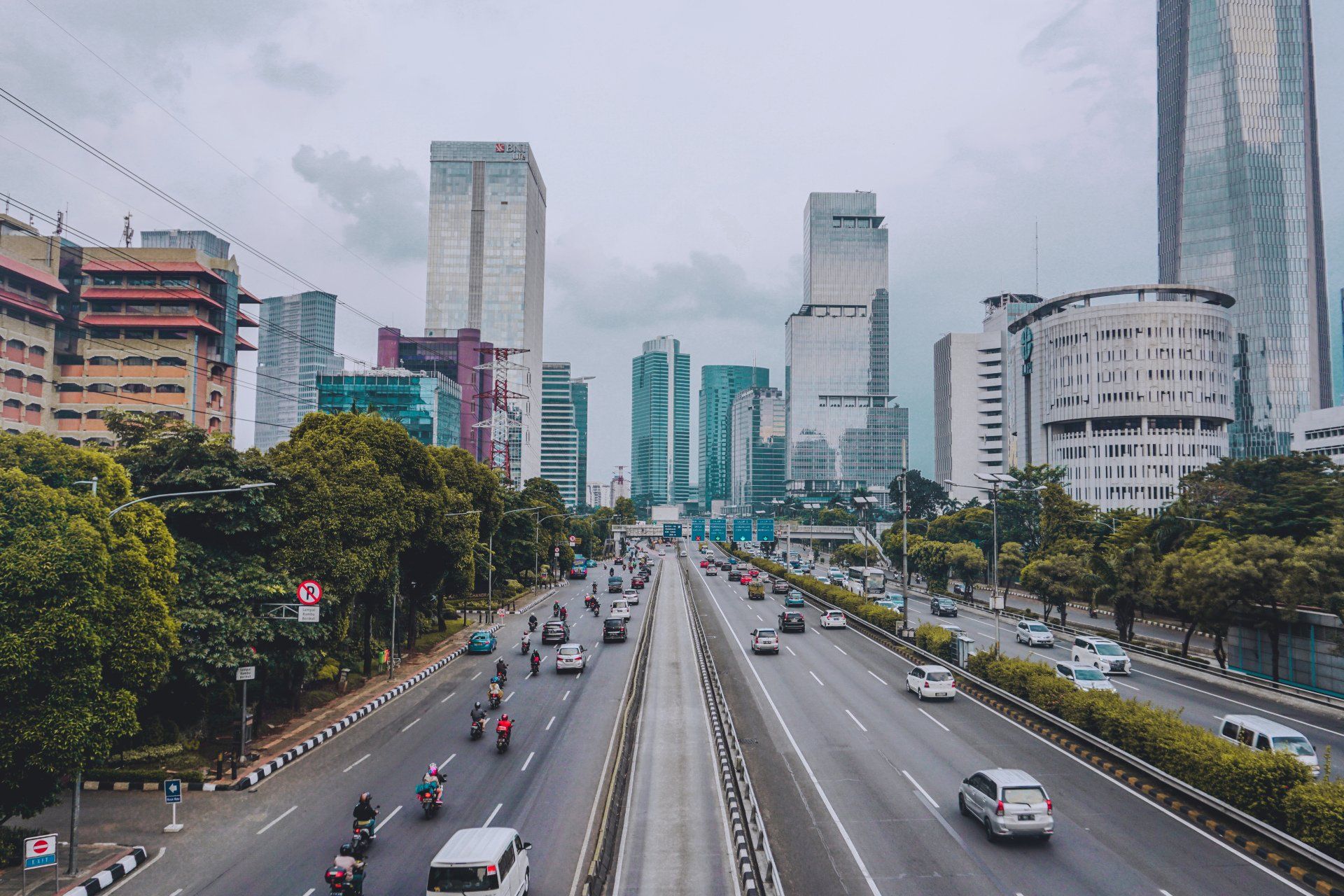 A highway in a city with a lot of traffic and buildings in the background.
