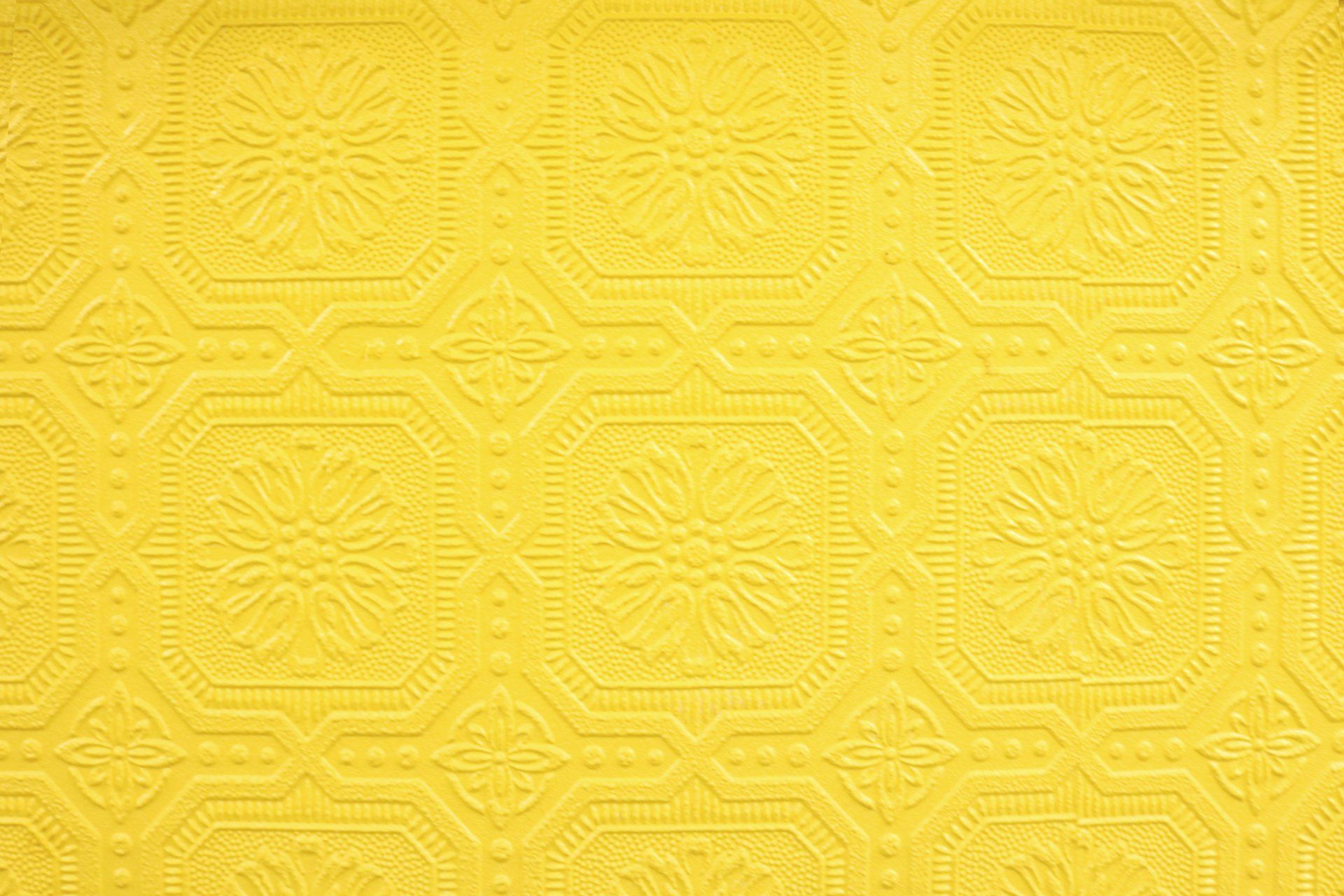 A close up of a yellow wallpaper with a pattern on it.