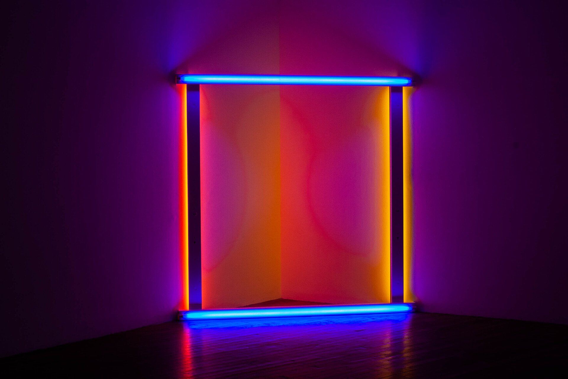 Een hoek van een kamer met een regenboog van neonlichten.