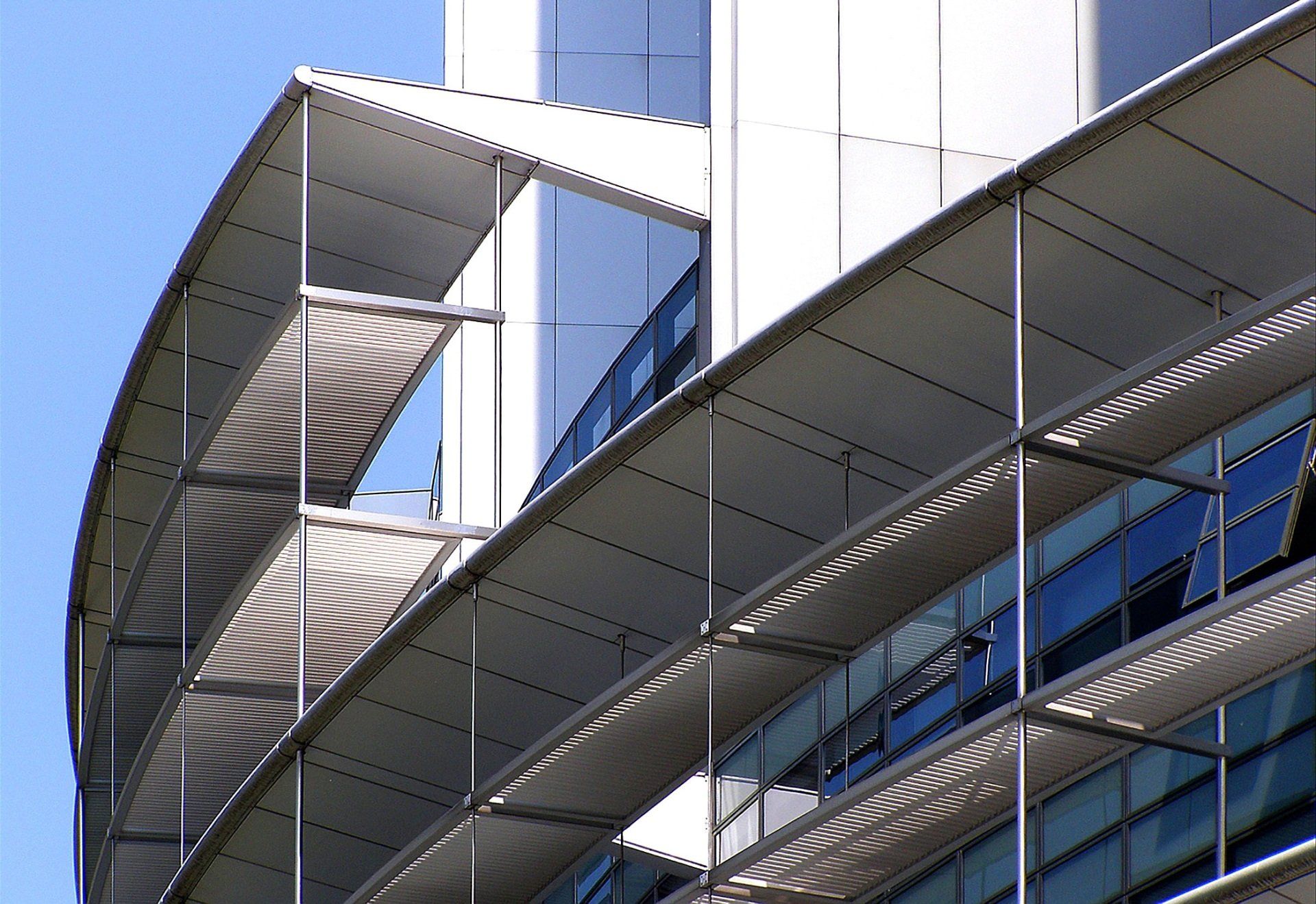 Modern building facade with curved metal walkways and glass windows