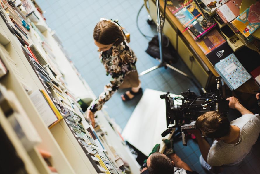 a group of people are standing in a room with a camera.