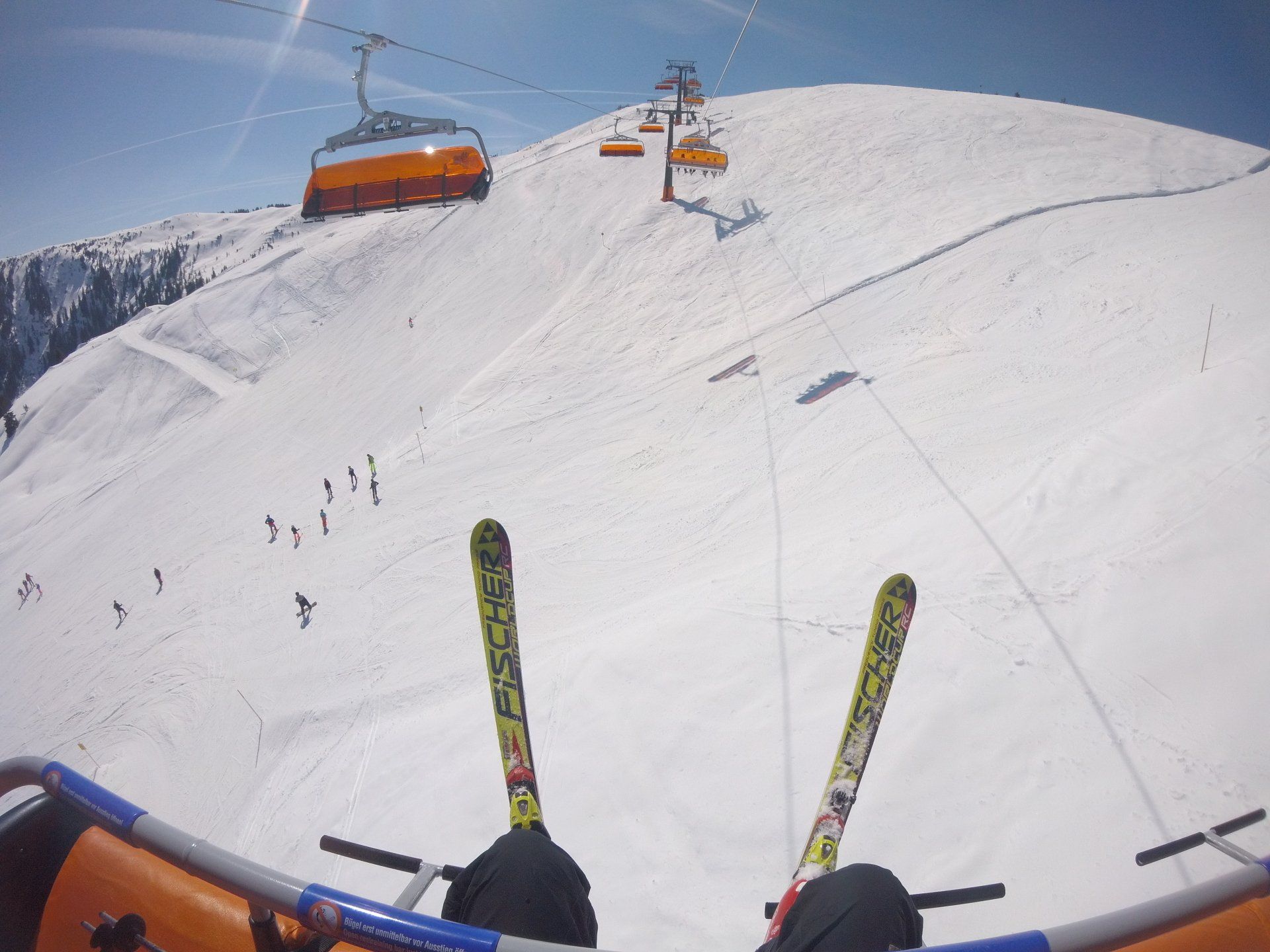 A ski lift is going up a snow covered mountain